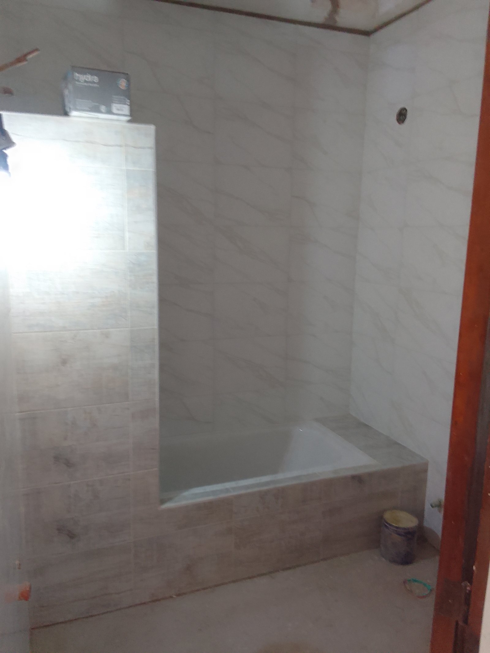 Baño en construcción con azulejos de mármol y madera — proyecto 2 Casas en Lanus, por Arquitecto Guido Niccoli, en B1824 Lanús