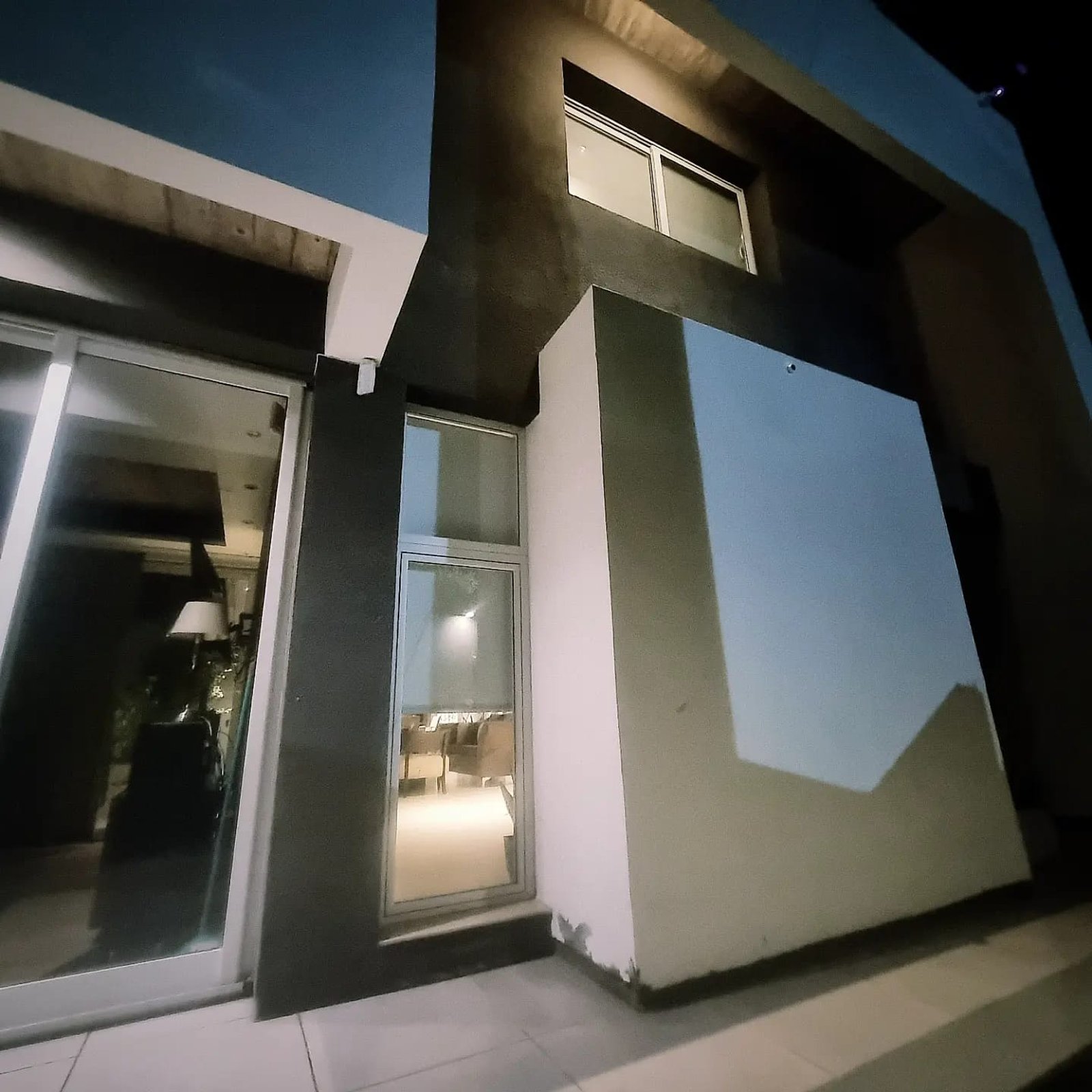 fachada moderna de noche con entrada de cristal — proyecto CASA ML , por ML ARQUITECTURA / ARQ. MARIANO LEOTTA, en J5400 Concepción