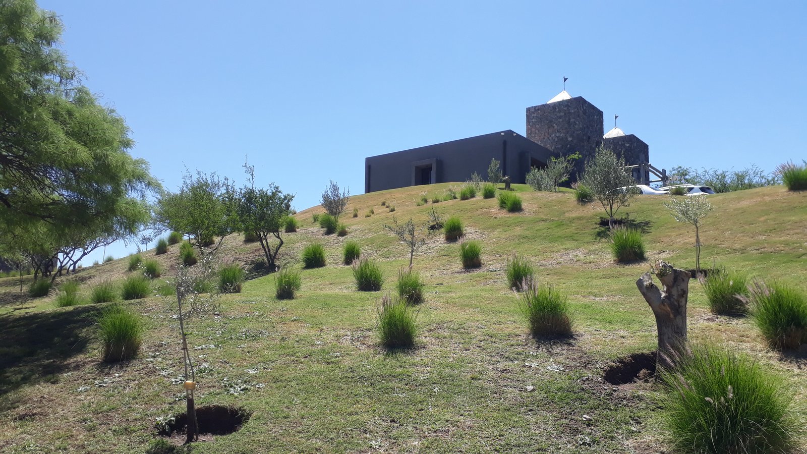 prédio moderno brutalista em encosta com vegetação — projeto El Terrón, por Estudio Rifahi, em Mendiolaza