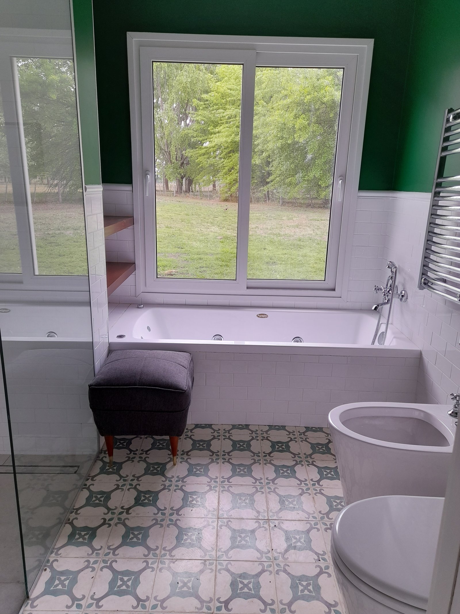 Baño moderno con vista al campo y piso con diseño — proyecto Casa de Campo, por Estudio Fernandez Long & asoc., en San Andres de Giles