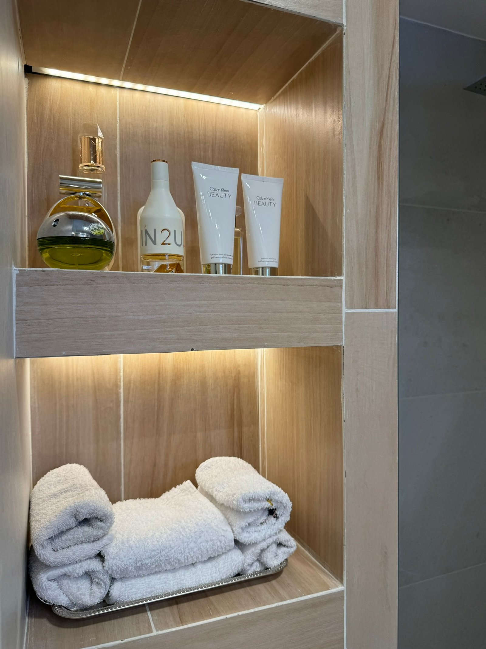 Estantería de madera empotrada en baño con iluminación indirecta — proyecto Bulnes, por MDBK Arquitectura, en Palermo