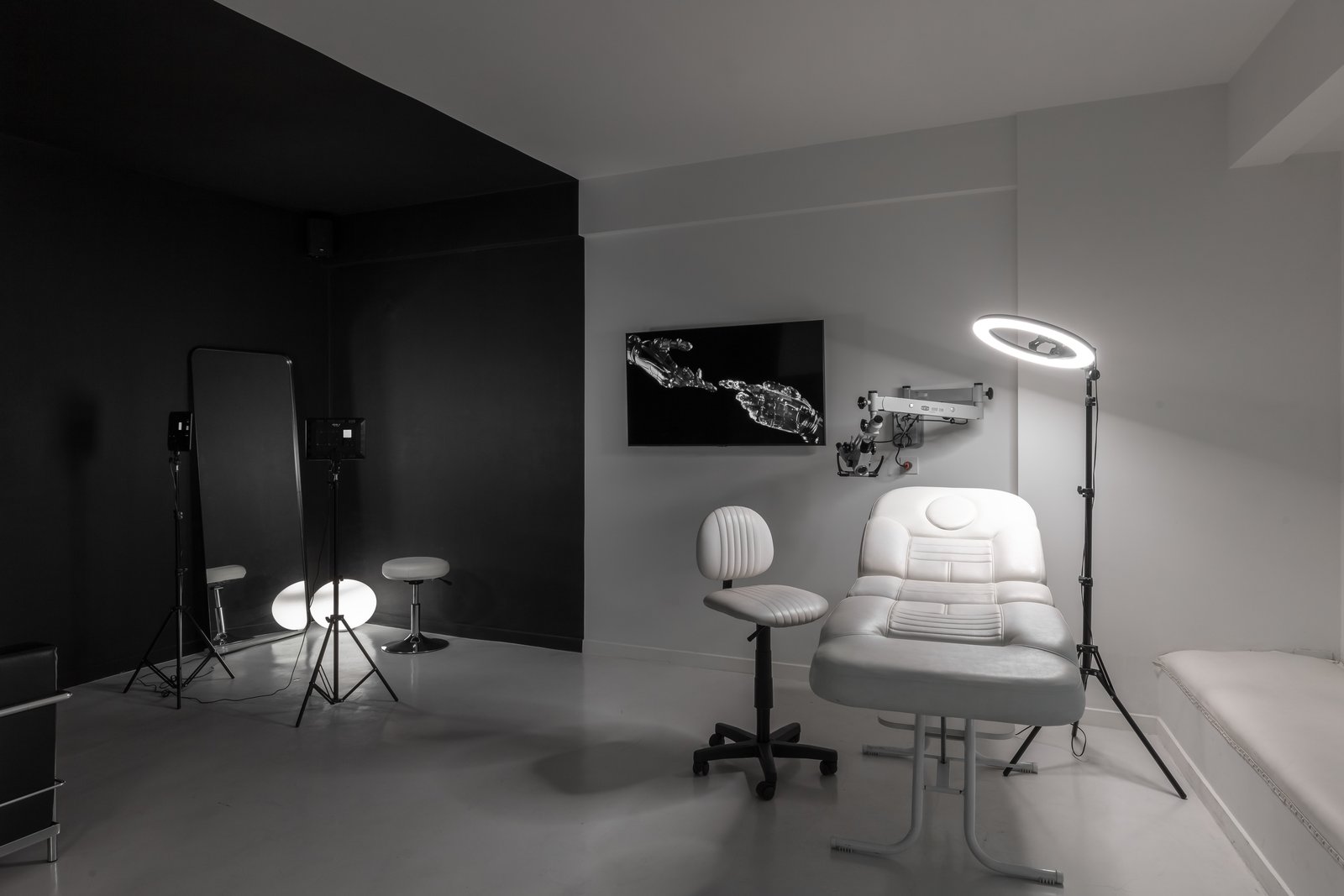 Consultorio moderno blanco y negro con camilla y aro de luz — proyecto Figueroa Alcorta | Rhinoplasty meets art, por Ren Studio, en Palermo Chico