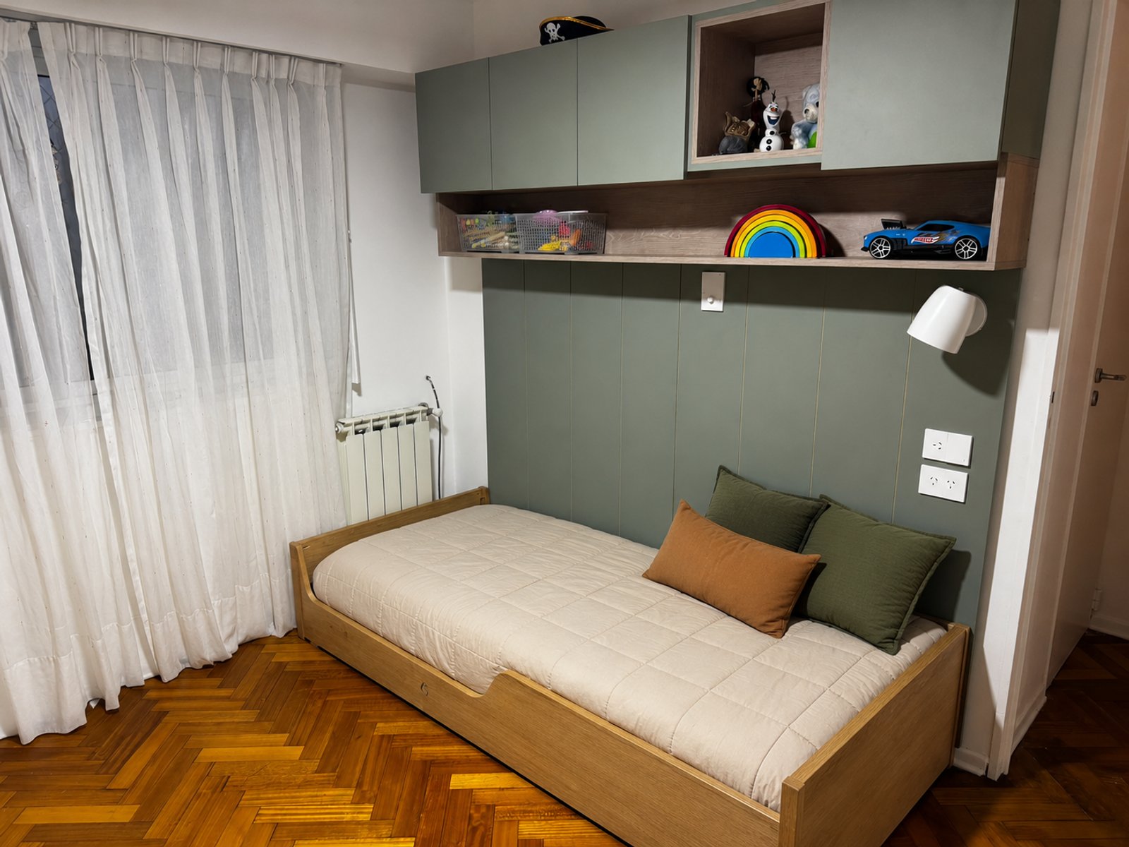 Dormitorio moderno con cama baja de madera y paneles verdes — proyecto Dormitorio infantil, por Casa Fi, en Villa Devoto