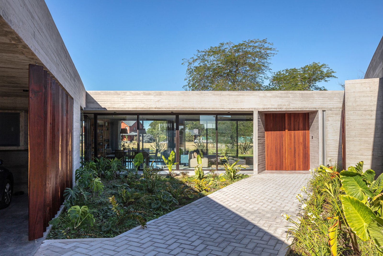 Casa moderna con fachada de hormigón y madera — proyecto Casa Pau, por Besonías Almeida arquitectos, en Guillermo Enrique Hudson