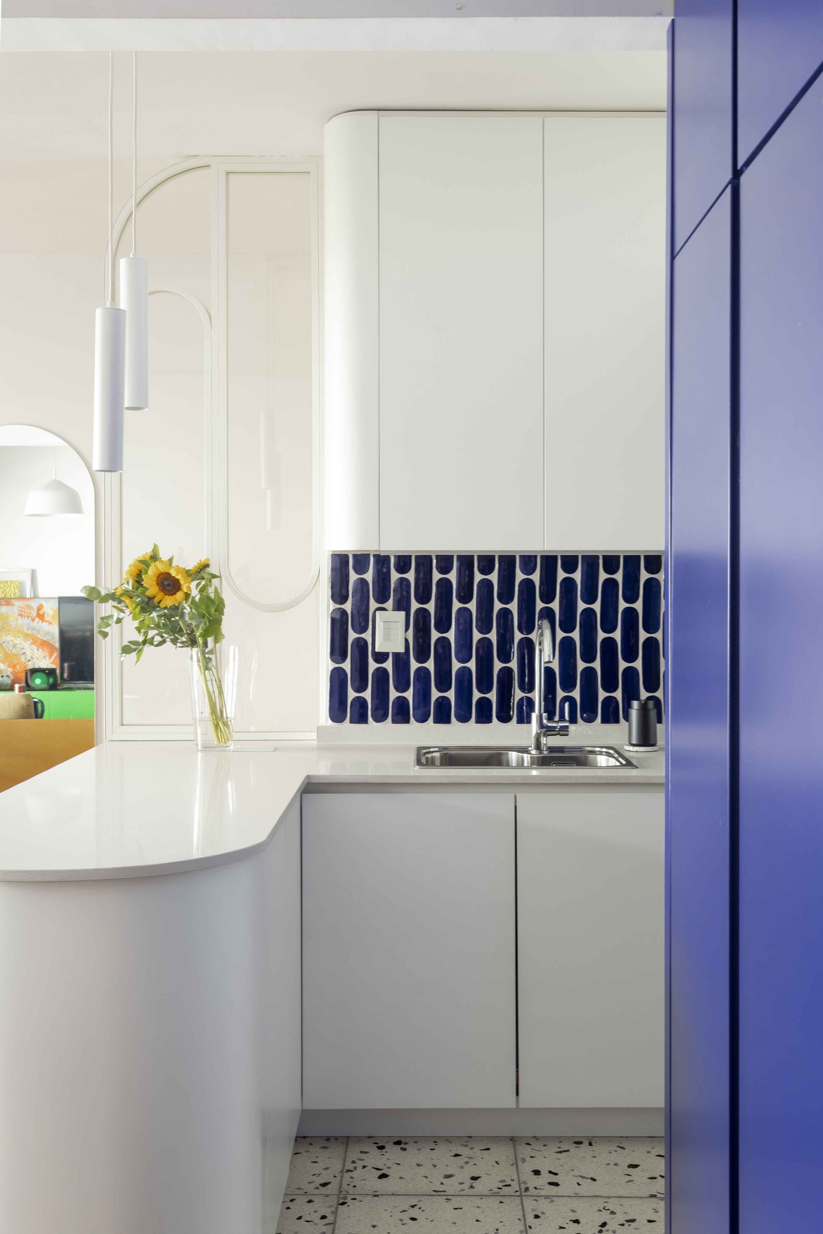 Cocina moderna con barra curva blanca y azulejos azules — proyecto Julián Alvarez, por Bouré Studio, en Palermo