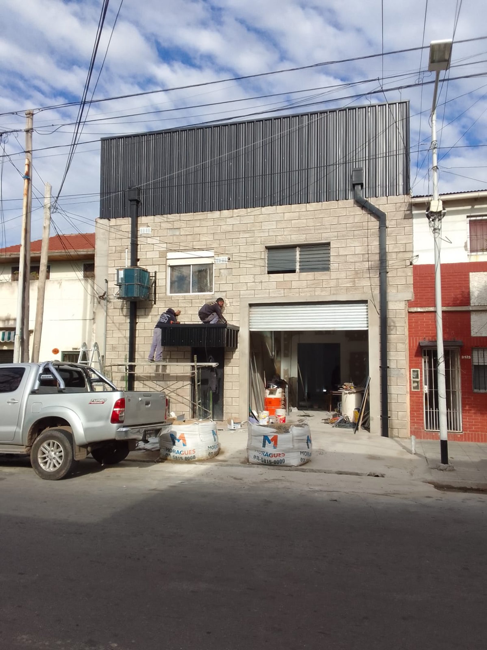 Fachada comercial en construcción con camión y materiales — proyecto Deposito en Avellaneda 3, por Arquitecto Guido Niccoli, en B1872 Sarandí