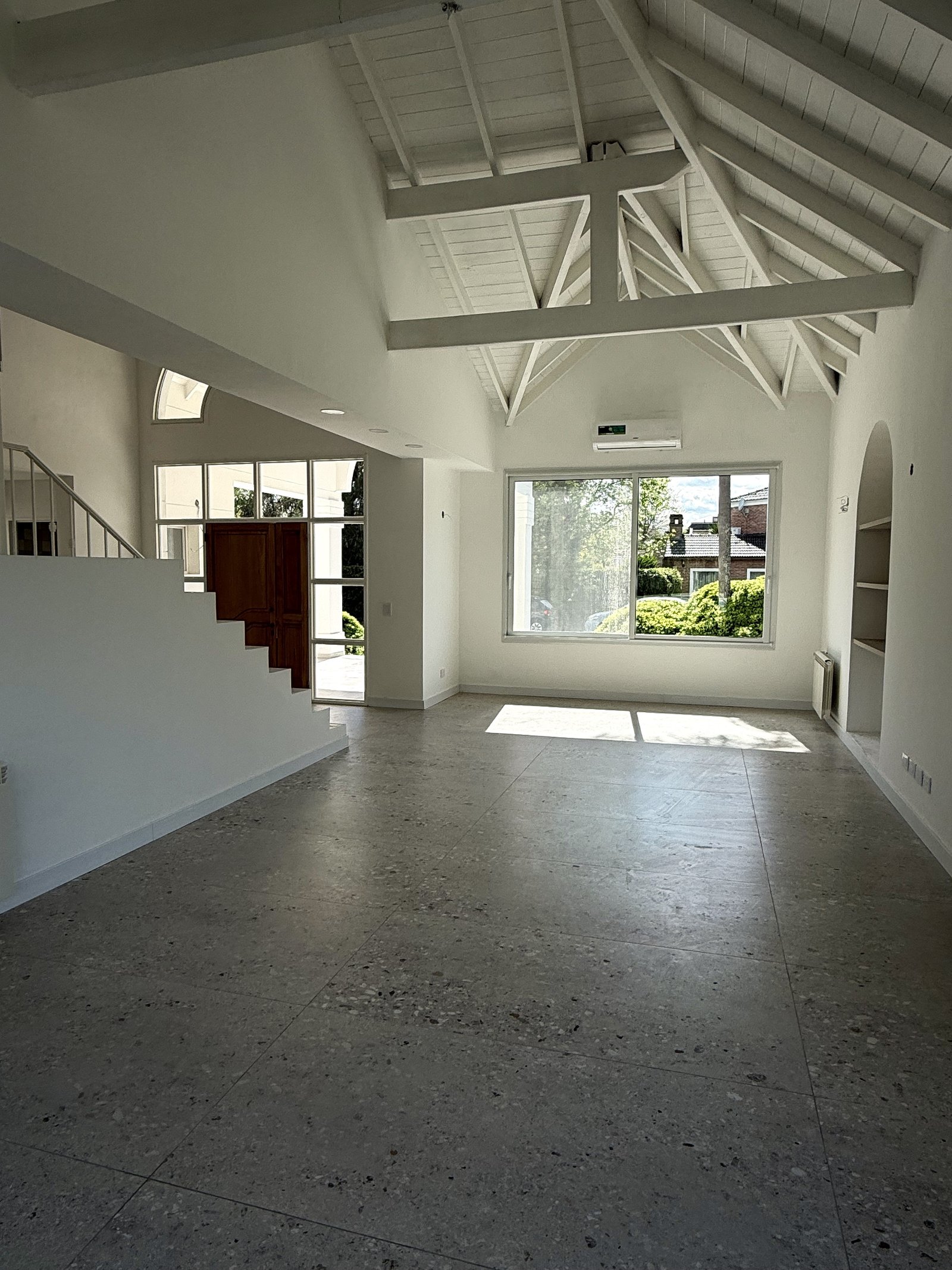 Sala de estar moderna com pé-direito alto e piso de terrazzo — projeto CASA LA CASUALIDAD, por Estudio Grupo 32, em Pilar
