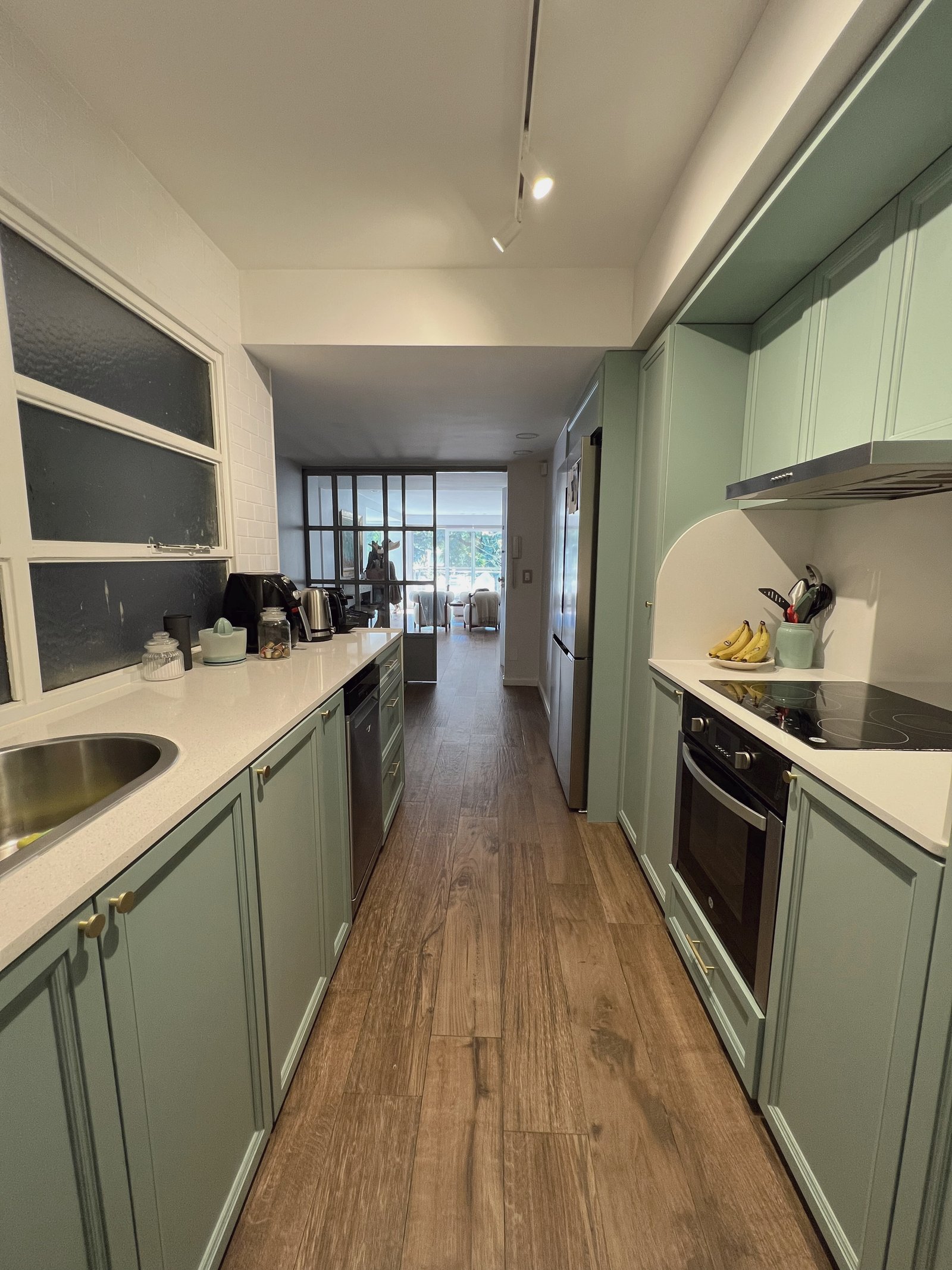 Cocina lineal con muebles verdes pálidos y mesada de mármol blanco — proyecto Figueroa Alcorta 2, por Equipe, en Buenos Aires