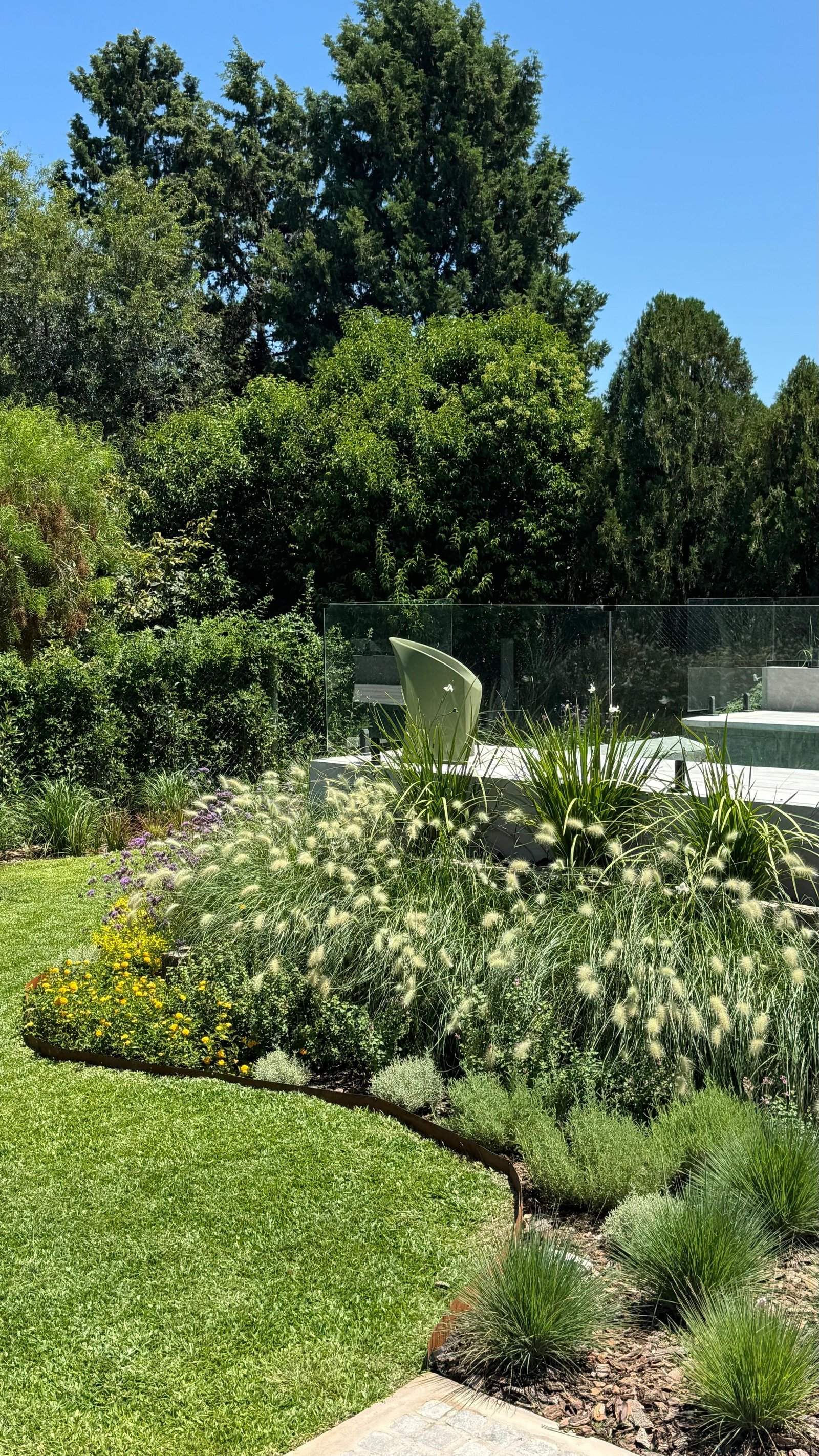 Jardim moderno com escultura verde, piscina infinita e grama ornamental — projeto La Paloma :: Villa Allende - Córdoba :: Paisajismo Residencial :: STIPA Arte Nat, por STIPA Arte N