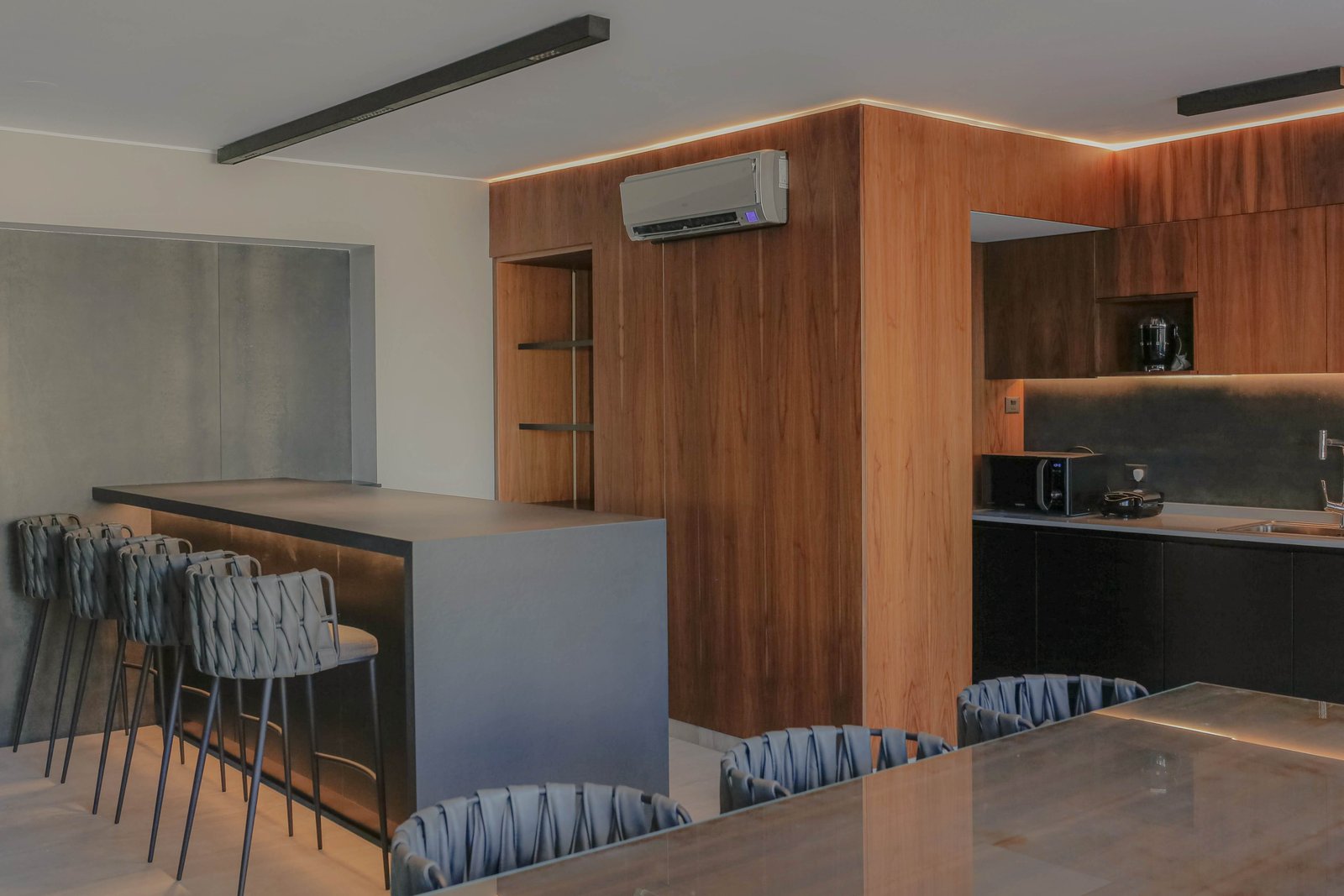 Cocina moderna con isla y paredes de madera — proyecto Quartier - Estudio CCWay, por ABEJA CONCEPT, en Palermo