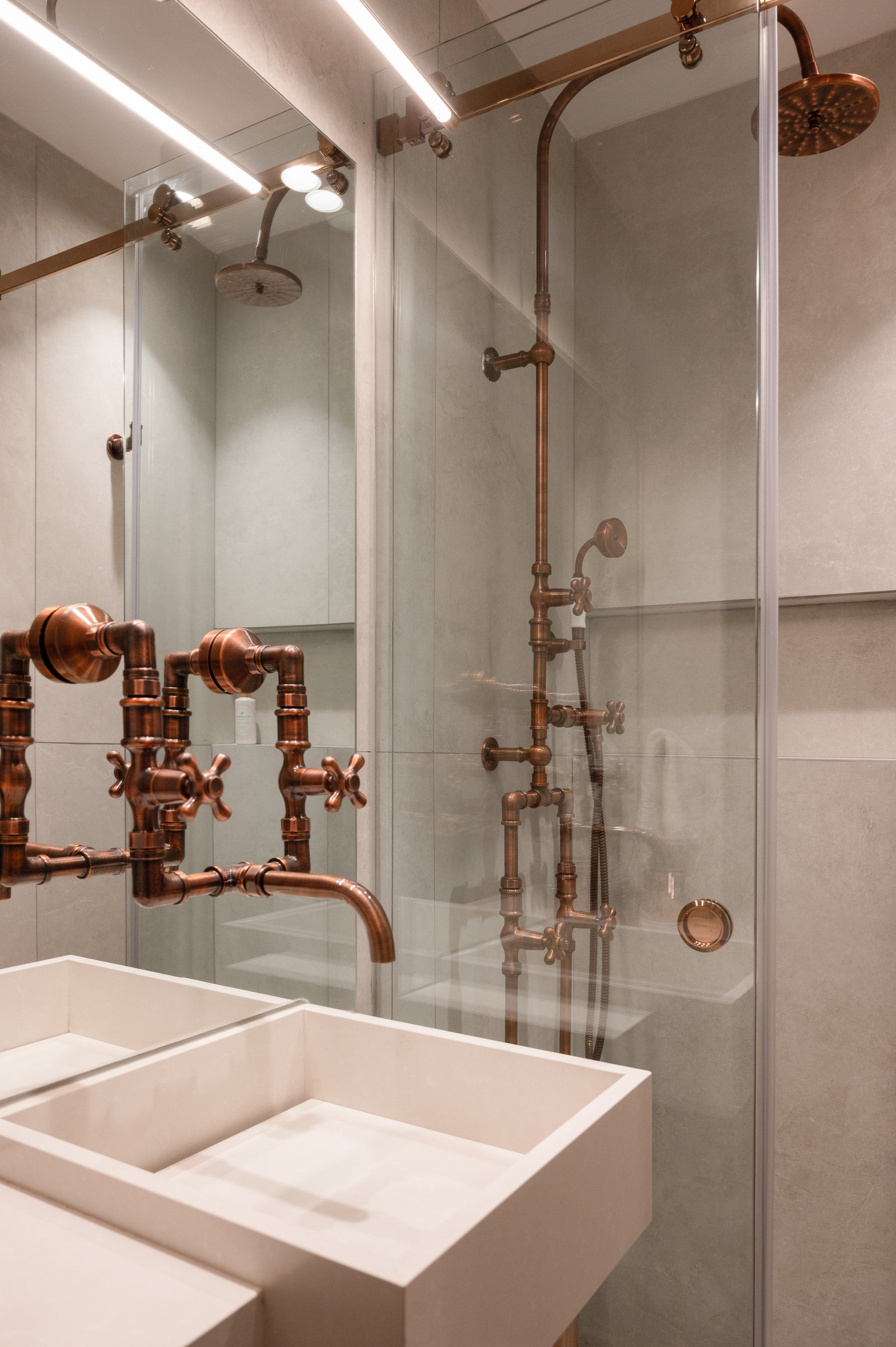 baño de estilo industrial con grifería de cobre y bachas de loza — proyecto LIBERTADOR DANDY, por AB ARQUITECTURA, en Recoleta