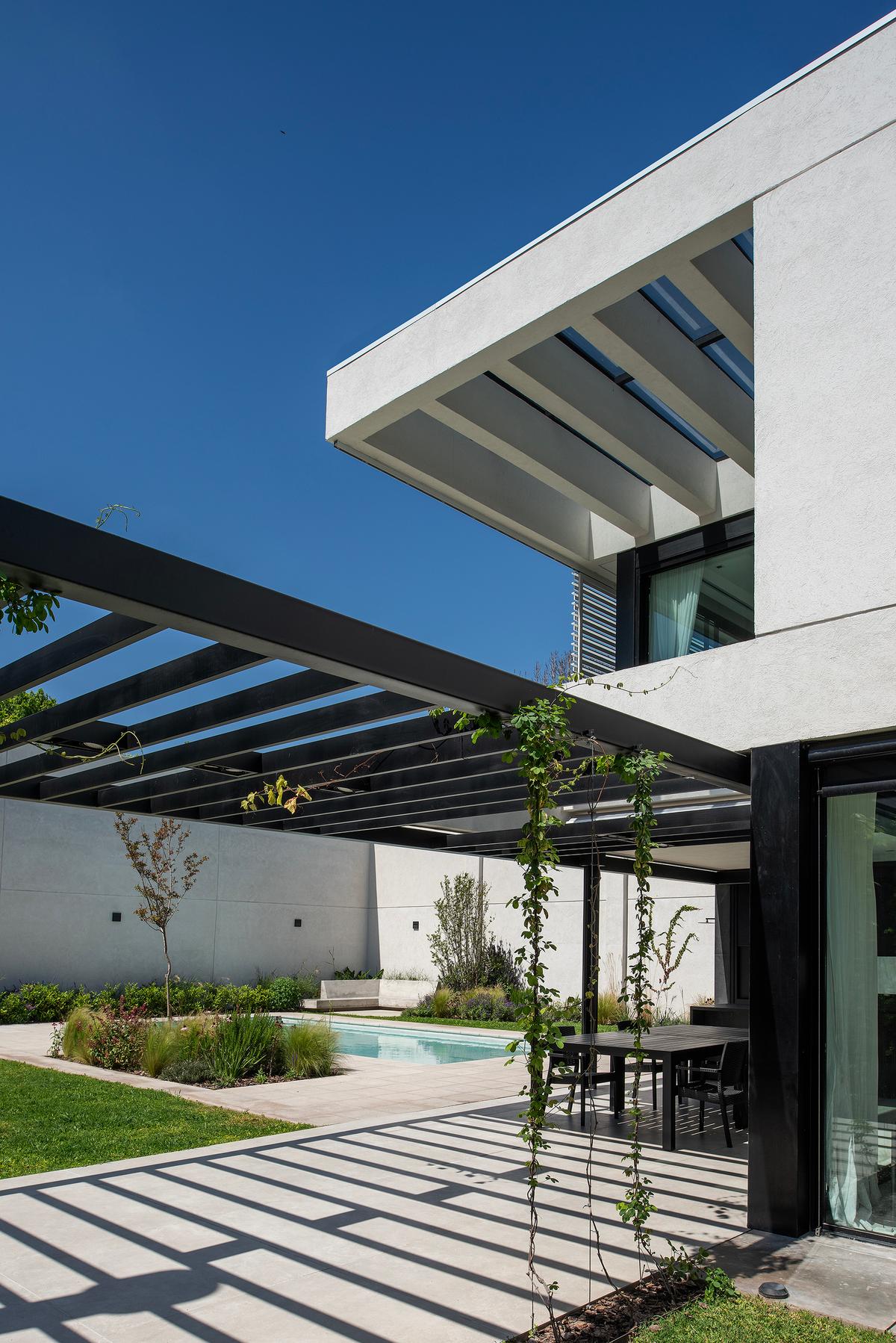 Área externa moderna com piscina e pergolado — projeto CASA SD28, por GMARQ, em Buenos Aires