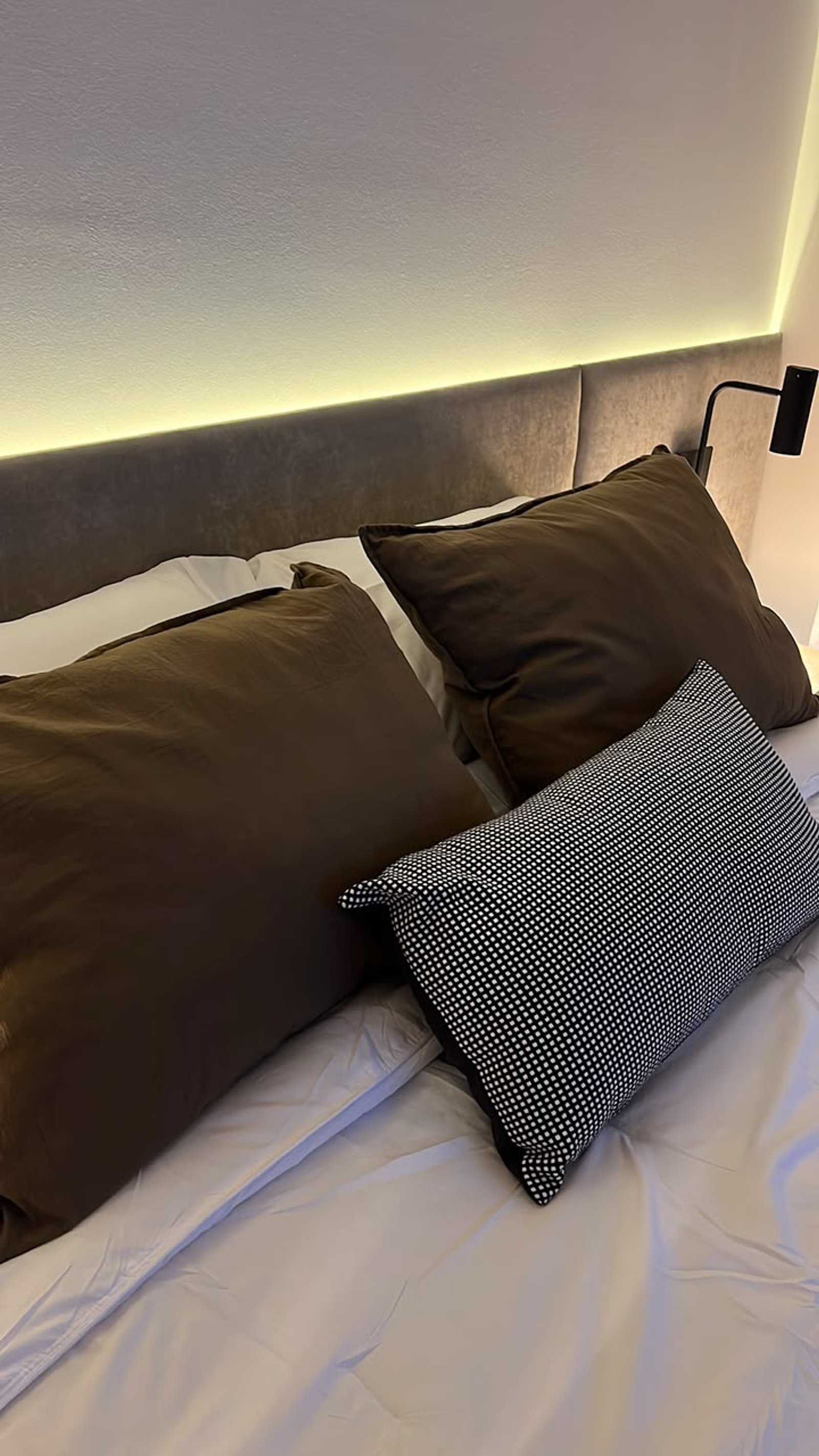 Dormitorio moderno con iluminación indirecta y almohadas decorativas — proyecto Proyecto Moreno, por Abelina Estudio, en Rosario