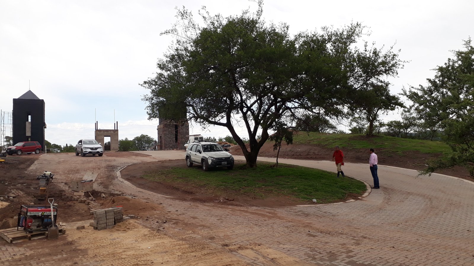 Fachada moderna rural con árboles y vehículos — proyecto El Terrón, por Estudio Rifahi, en Mendiolaza