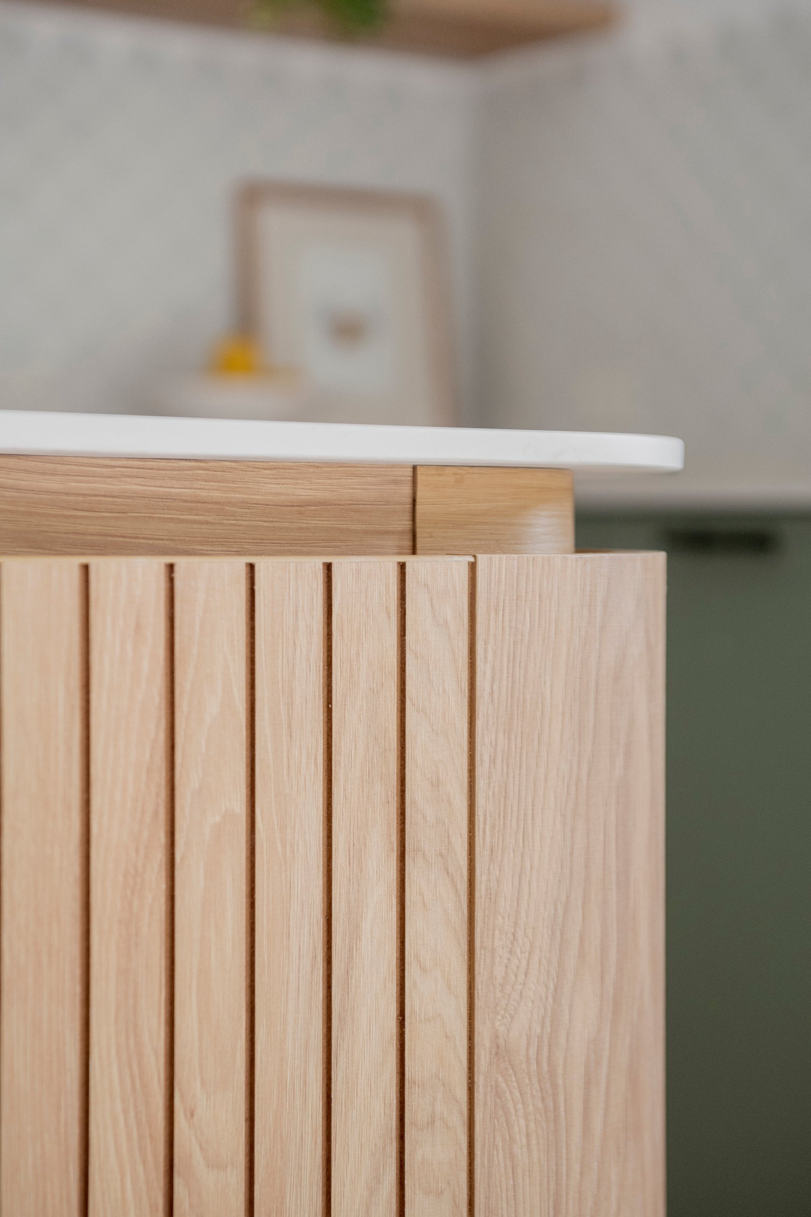 cocina moderna con revestimiento de madera y mesada blanca — proyecto Ballester, por BK Arquitectos, en B1653 Villa Ballester