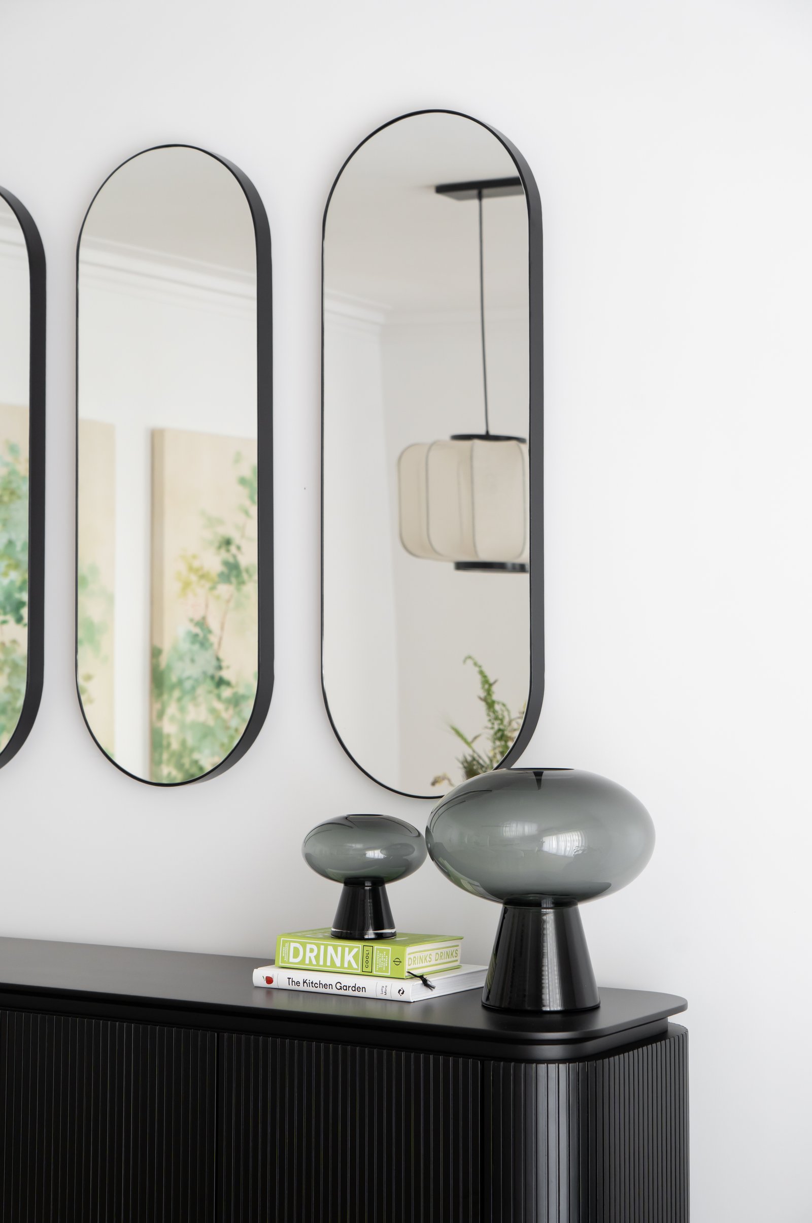Sala de estar moderna con espejos altos, mueble negro acanalado y lámparas de vidrio — proyecto Rodriguez Peña , por BK Arquitectos, en Recoleta