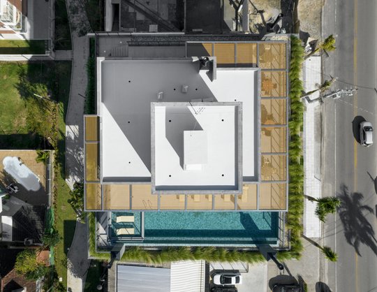 Vista aérea de patio moderno con pileta y deck de madera — proyecto Edifício Residencial Meraki Beach, por Ruschel Arquitetura e Urbanism