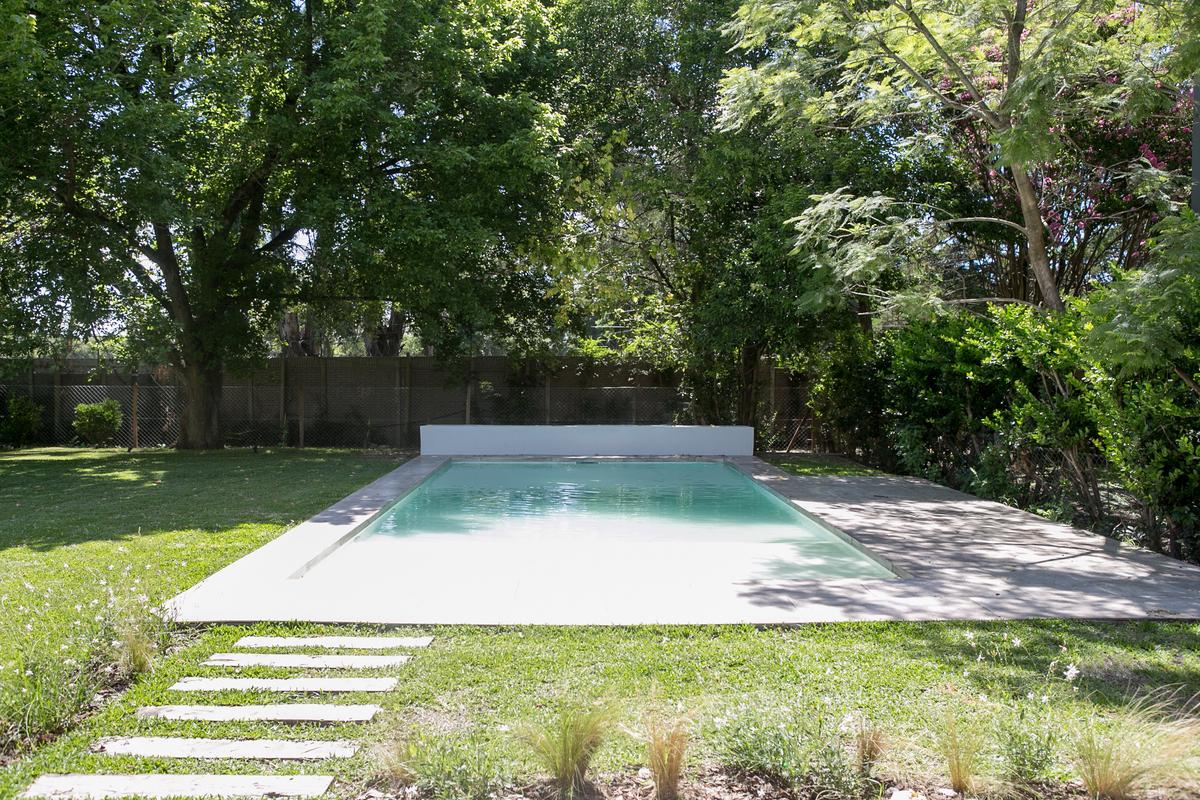 Piscina rectangular moderna al aire libre con deck de madera y jardín — proyecto Bosque Chico, por Estudio Arq. María Sioli, en Garin