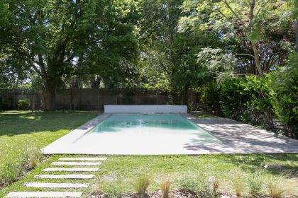 Piscina rectangular moderna al aire libre con deck de madera y jardín — proyecto Bosque Chico, por Estudio Arq. María Sioli, en Garin
