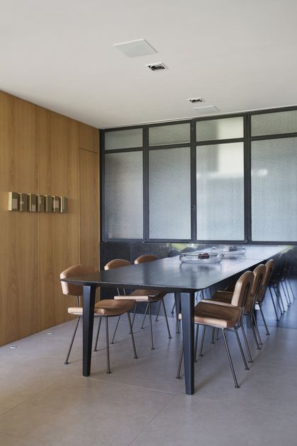 Comedor moderno con mesa oscura, sillas de cuero y ventanal — proyecto BL House, por Studio Ro-ca