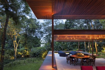Galería moderna con techo de madera y vista al jardín arbolado — proyecto Residência GS, por Gil Fialho