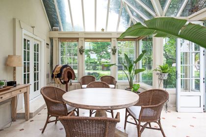 Galería luminosa con techo vidriado y muebles de ratan alrededor de mesa redonda — proyecto Casa Tortugas , por Estudio Du , en Tortugas Country Club