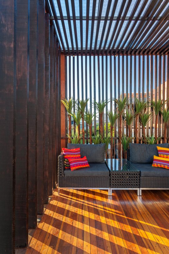 Terraza moderna con pergola de madera, sofá gris y plantas — proyecto CASA RR, por Frederico Bicalho Arquitetura