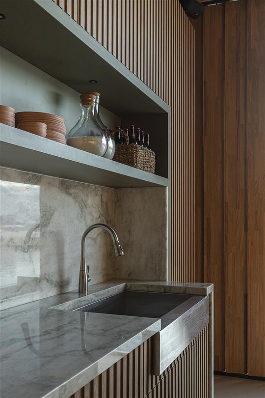 Cocina minimalista con mesada de mármol gris y detalles en madera — proyecto Refugio do Forte, por Milcent Arquitetura