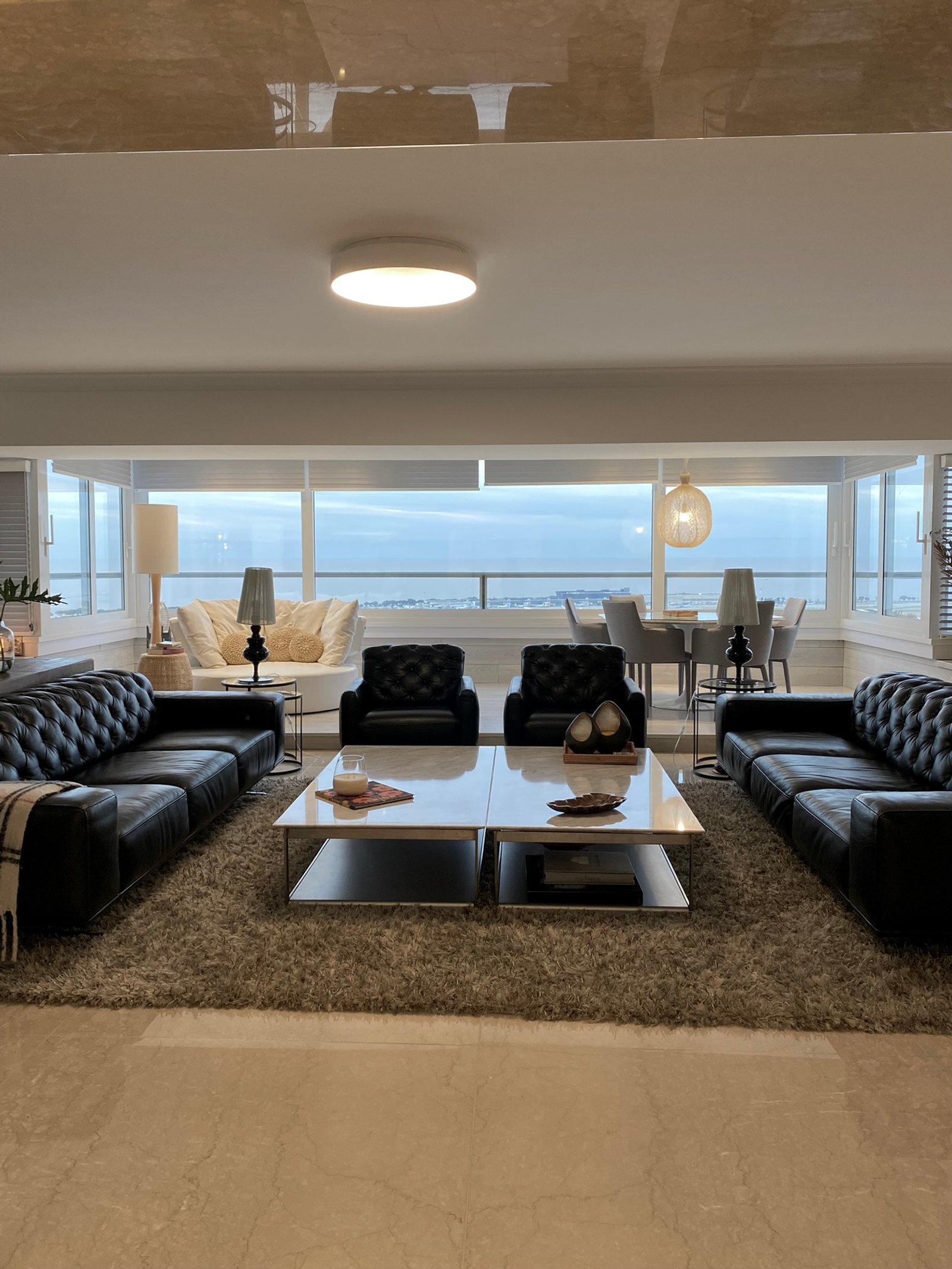 Living moderno con vista al mar y muebles de cuero negro — proyecto Libertador I, por MDBK Arquitectura, en Palermo