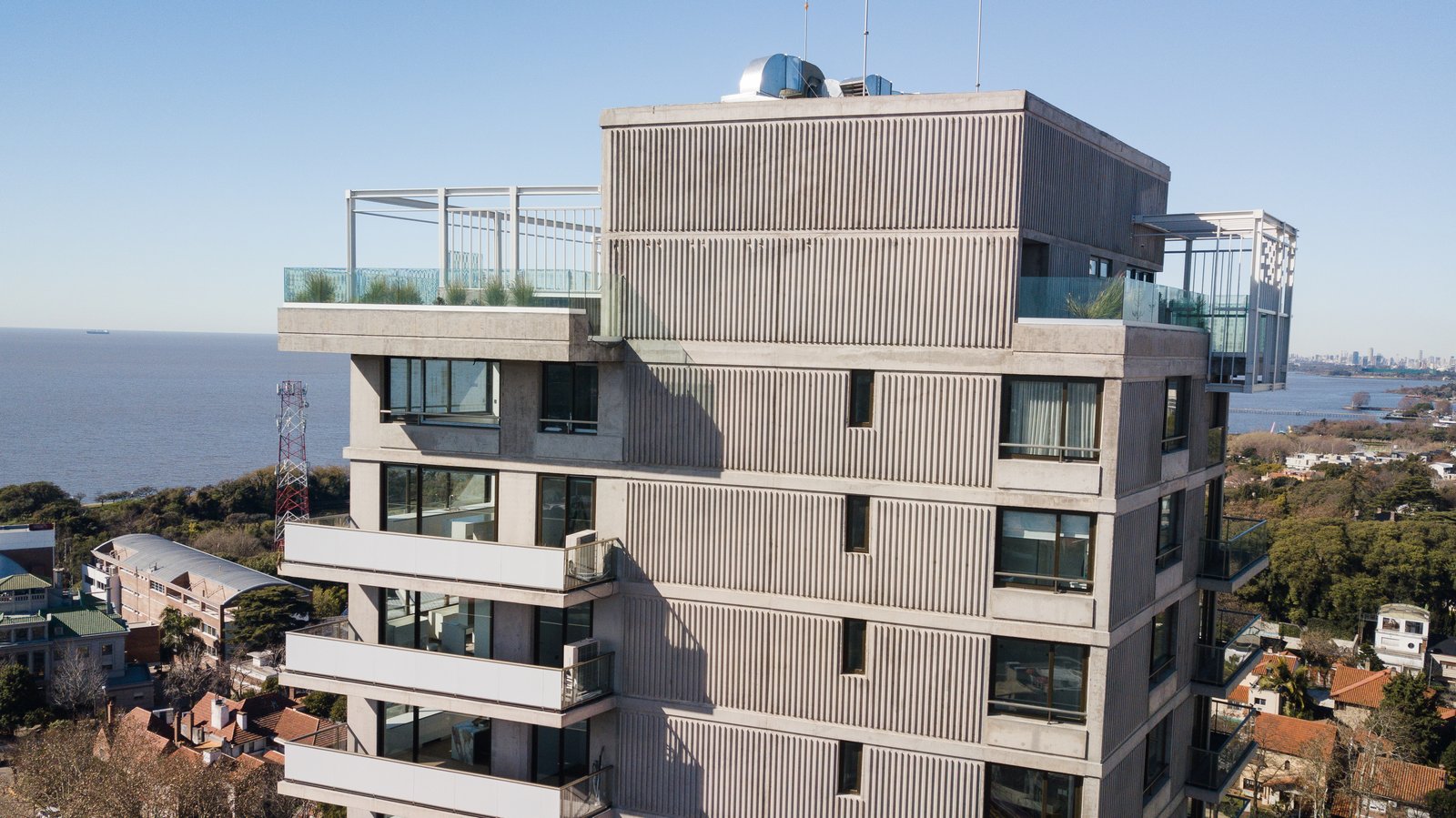 Edificio moderno de hormigón con balcones y ventanas amplias — proyecto Barlovento Towers, por MUCHTEK, en La Lucila
