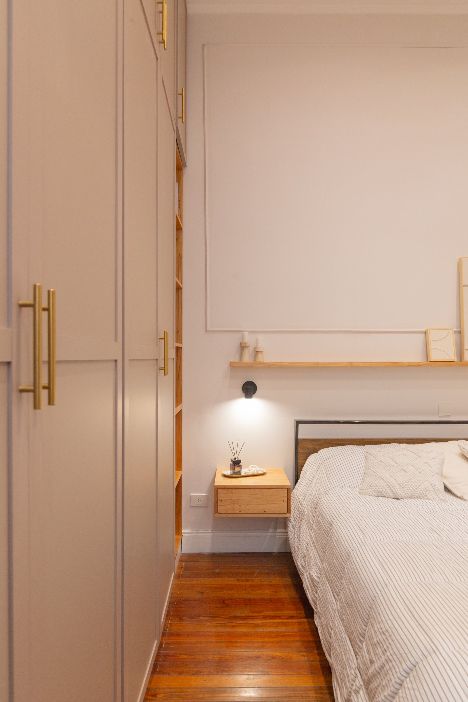 Dormitorio minimalista con placard beige y cama a rayas — proyecto Anchorena, por Martina Kleinert, en Palermo