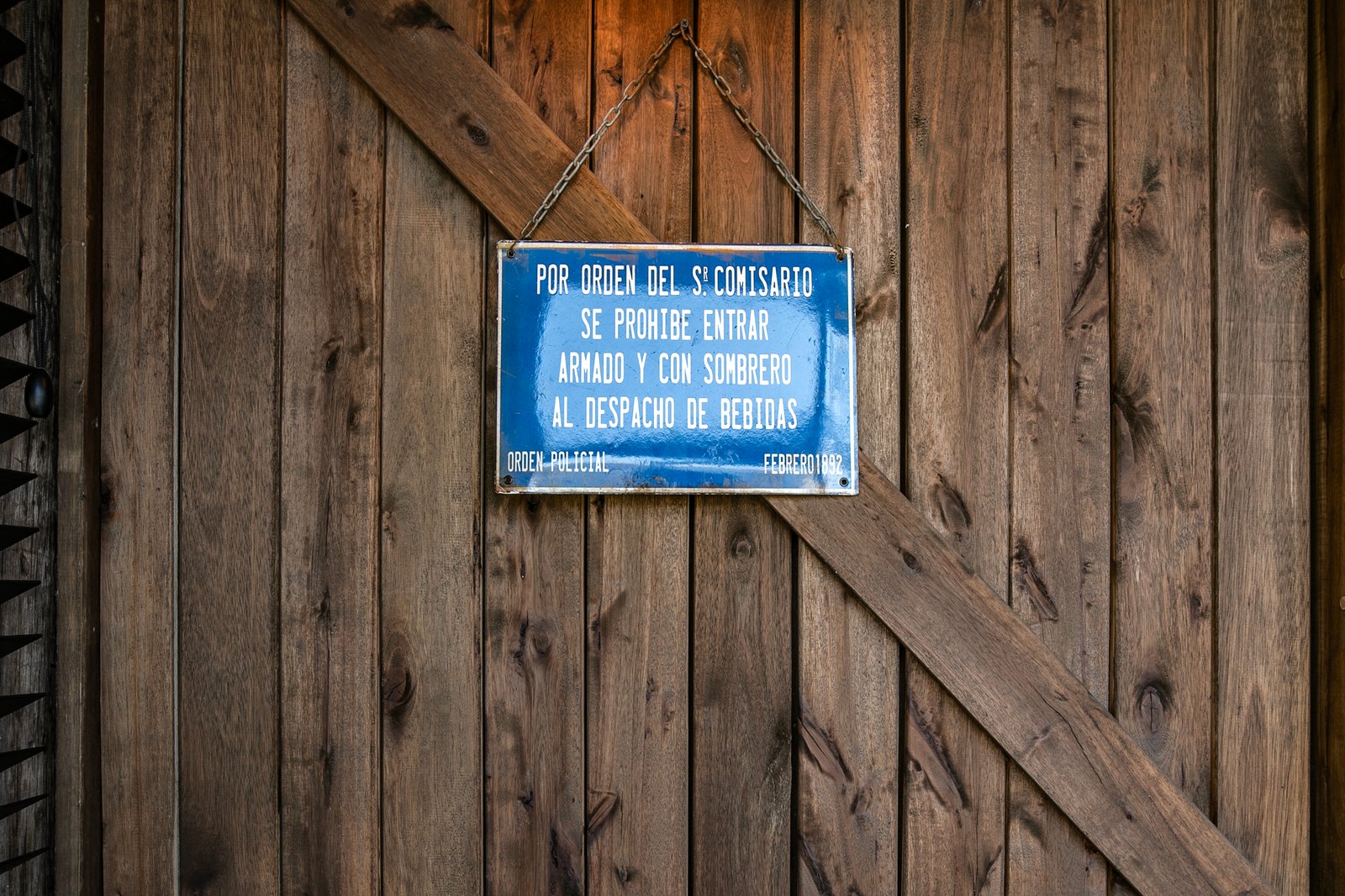 fachada rústica de madeira com placa proibindo armas e álcool — projeto Barreto, por Estudio Losa, em Palermo