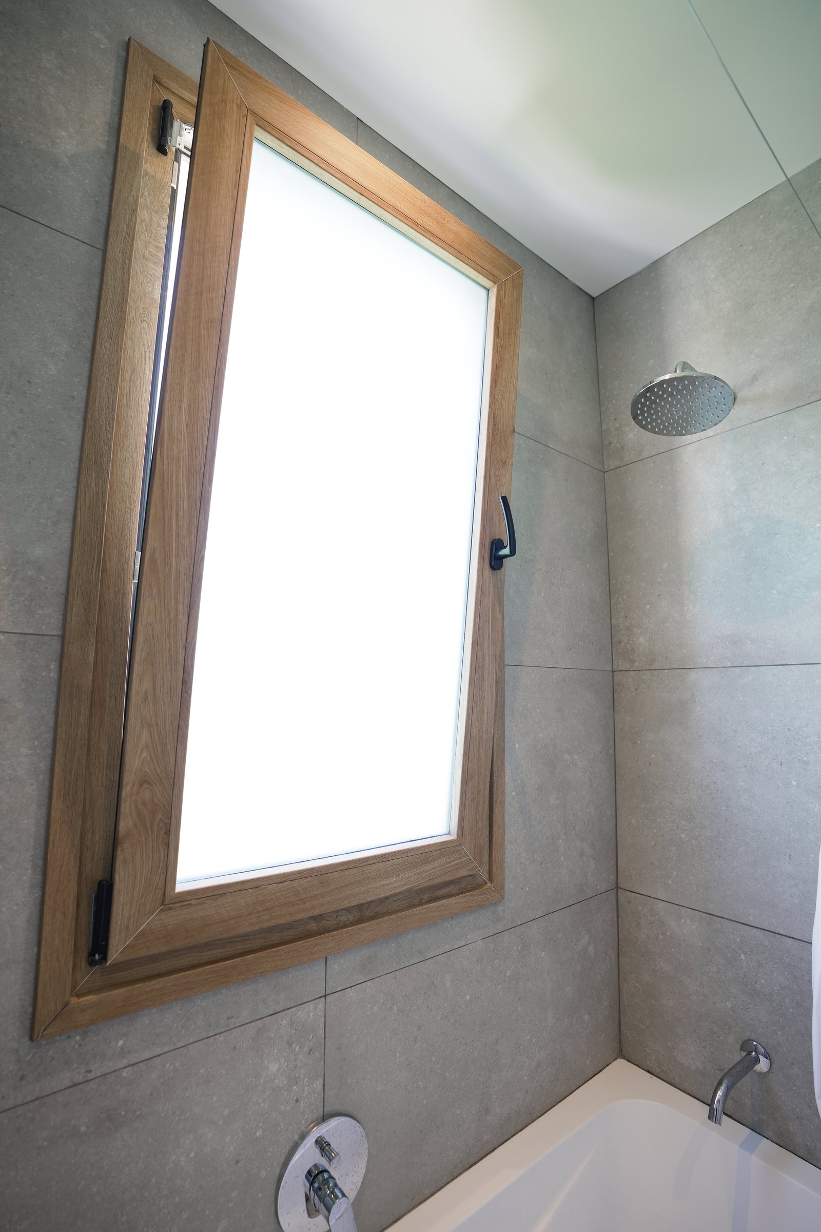 Baño minimalista con bañera exenta y ventana de madera — proyecto Baños, por CASA1-TROMEN, en Bella Vista