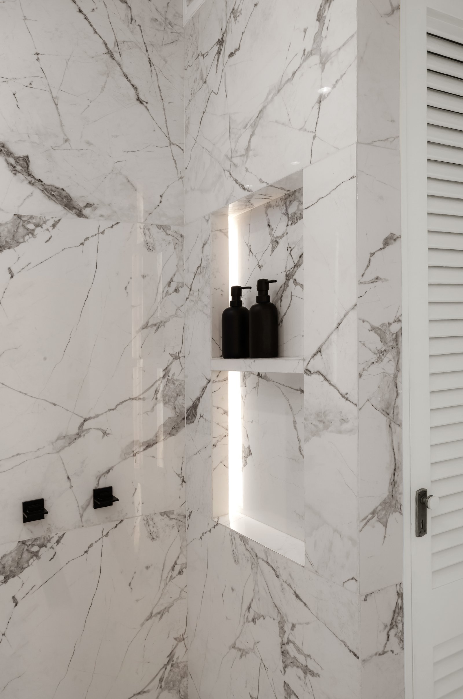 Baño moderno con paredes de mármol blanco y ducha empotrada — proyecto Alvear | Redefining luxury, por Ren Studio, en Recoleta