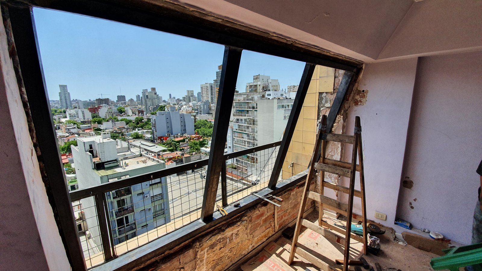 Varanda em construção com vista urbana e janelas amplas — projeto Aberturas DVH PVC - Reemplazo, por RenovArqui, em Palermo