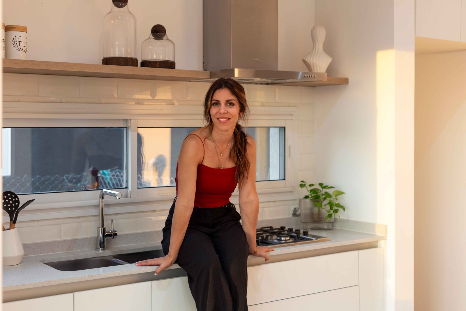 Cocina moderna con mujer sentada en la isla, estilo nórdico — proyecto San Simon I, por Estudio Stepa, en Ezeiza