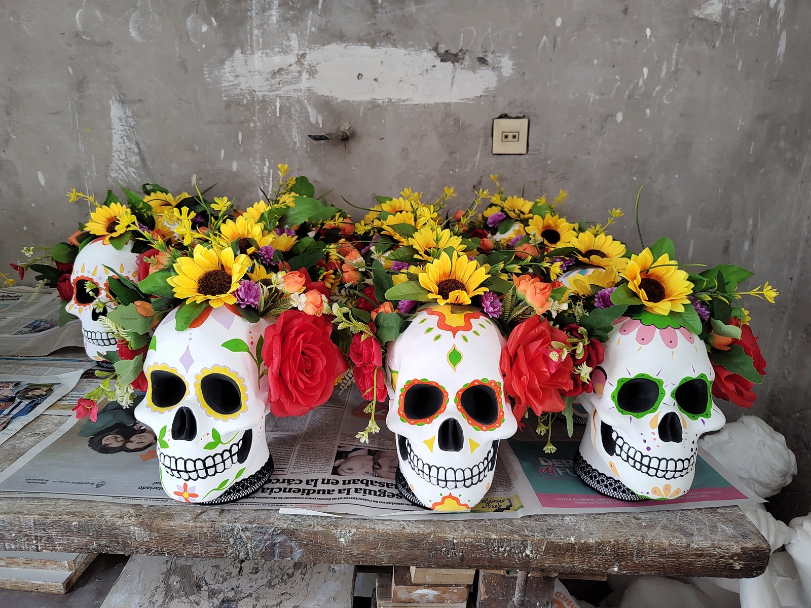 Craneo decorativo con flores frente a pared rústica — proyecto Calaveras y Catrinas, por Arte Umbra, en Cdad. Autónoma de Buenos Aires