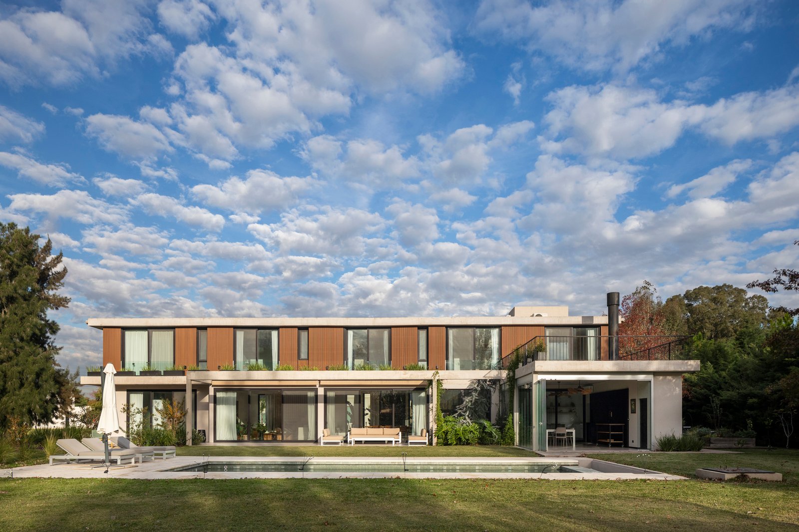 Fachada moderna con piscina y patio — proyecto CASA HS143, por A'PRIMA - Arquitectura Sustentable, en km 7.5 Ruta 25