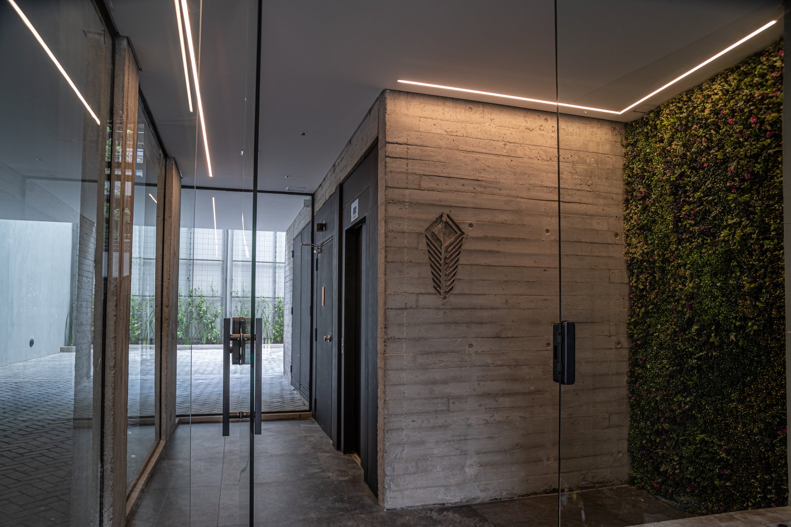 corredor moderno com parede de concreto e parede verde — projeto Edificio Aranguren, por LW Lopez Wolder arquitectos, em C. Dr. Juan Felipe Aranguren 1536
