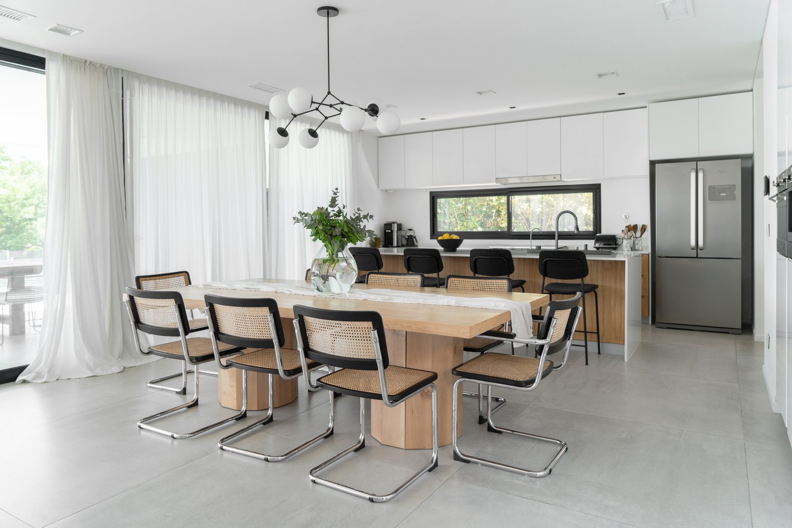 Comedor moderno abierto con isla de cocina y mucha luz natural — proyecto PROYECTO VISTAS, por July Acosta Home, en Belén de Escobar