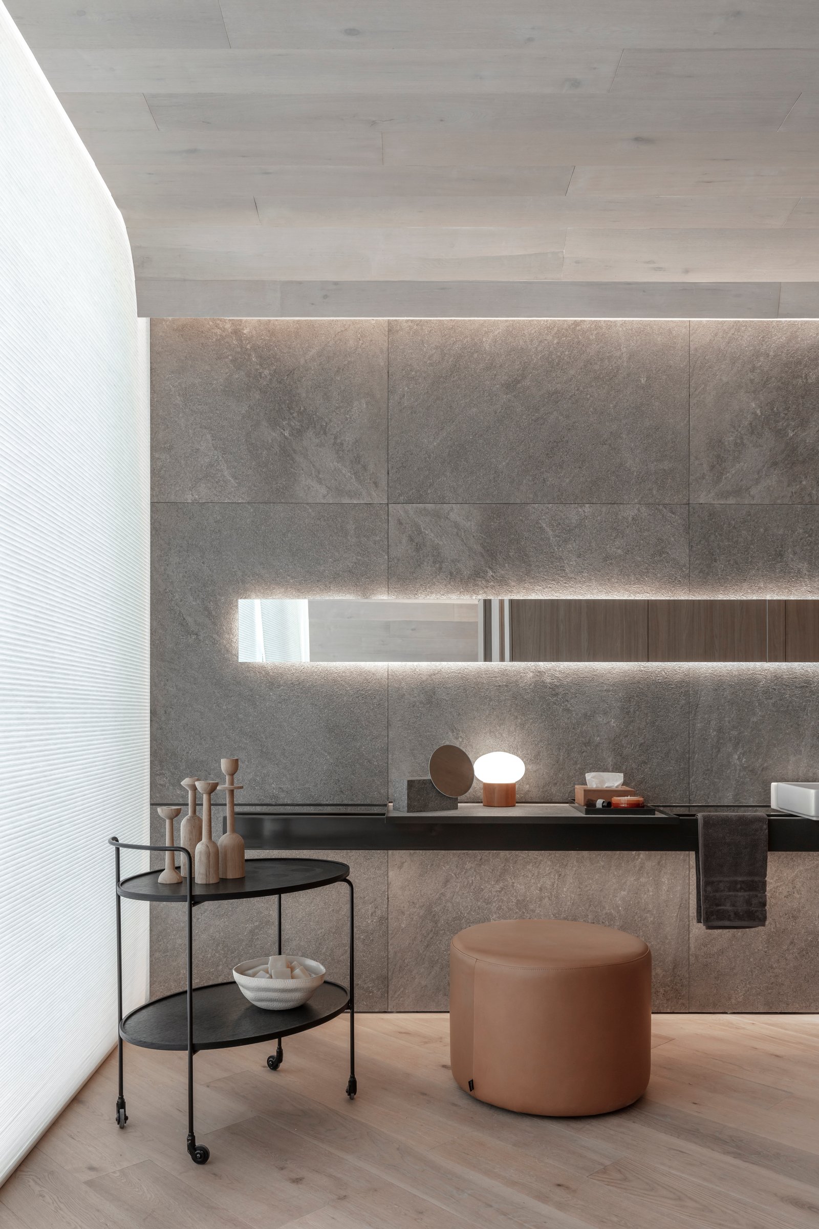 Banheiro moderno com parede de pedra, iluminação indireta e móvel preto — projeto Casa Foa 2024 | Ritual de bienestar | Wellness ritual | Lucia Quinteros, por Ren Studio, em Cdad. 