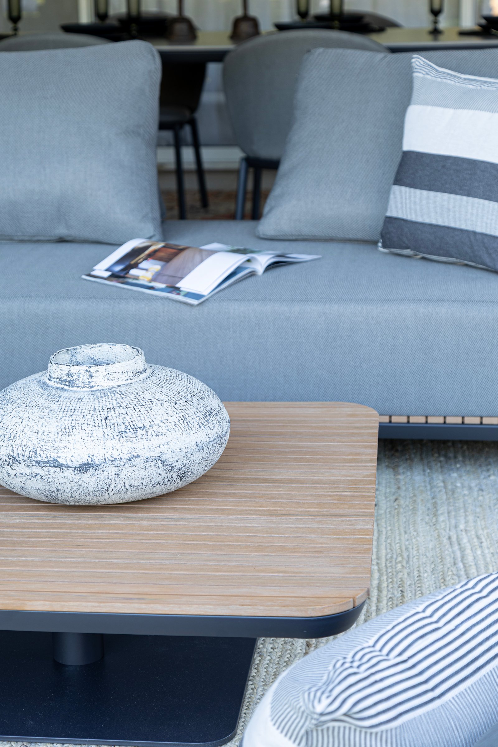Sofá moderno cinza com mesa de centro de madeira e vaso texturizado — projeto Nuevos diseños de Muebles de Exterior, por DESDE ASIA, em Malabia 1359