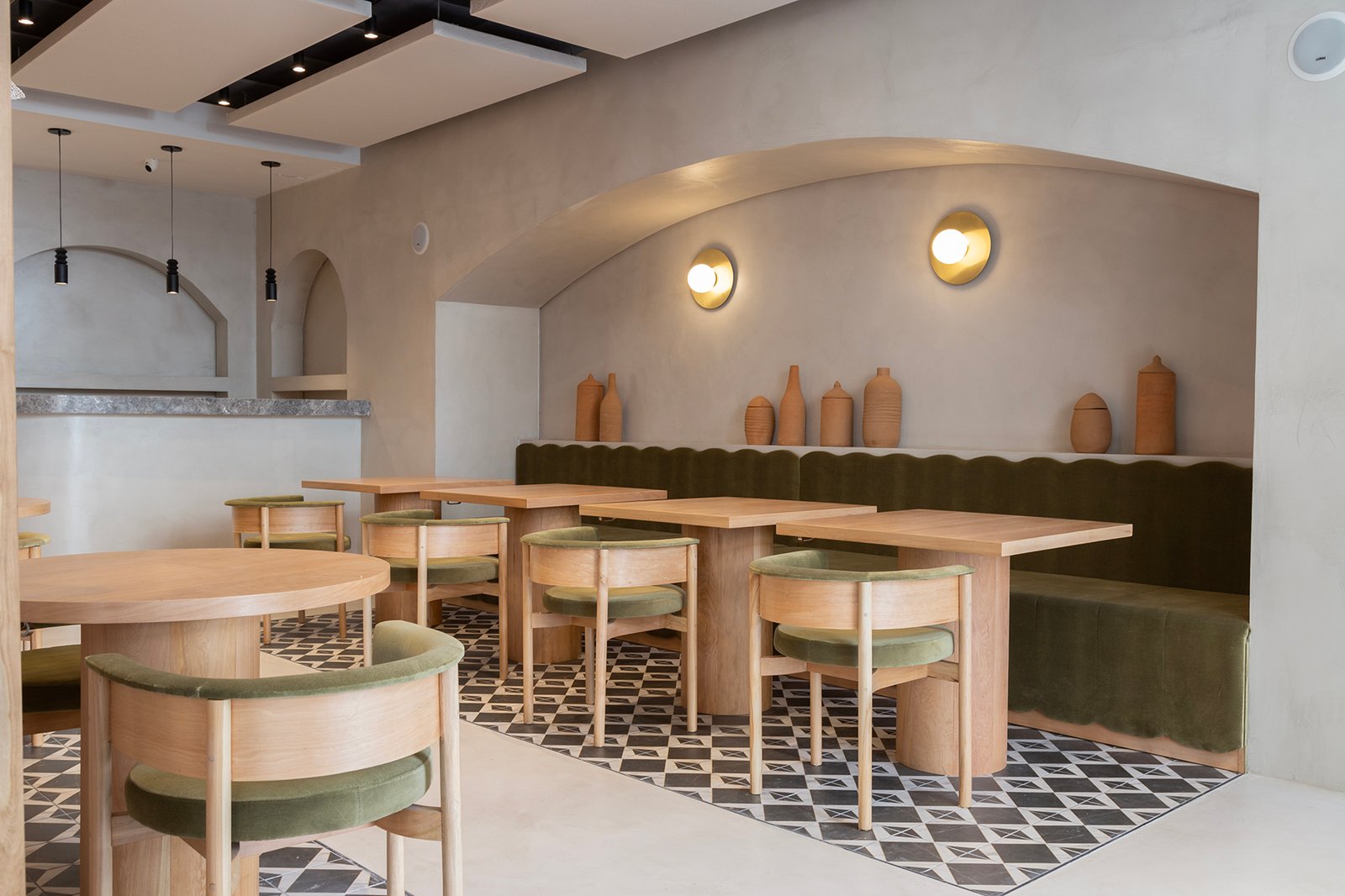 Sala de jantar moderna com mesas redondas e assentos curvos verdes — projeto HATSU Palermo - MZV Arquitectura, por Gaby Alfonso, em Palermo