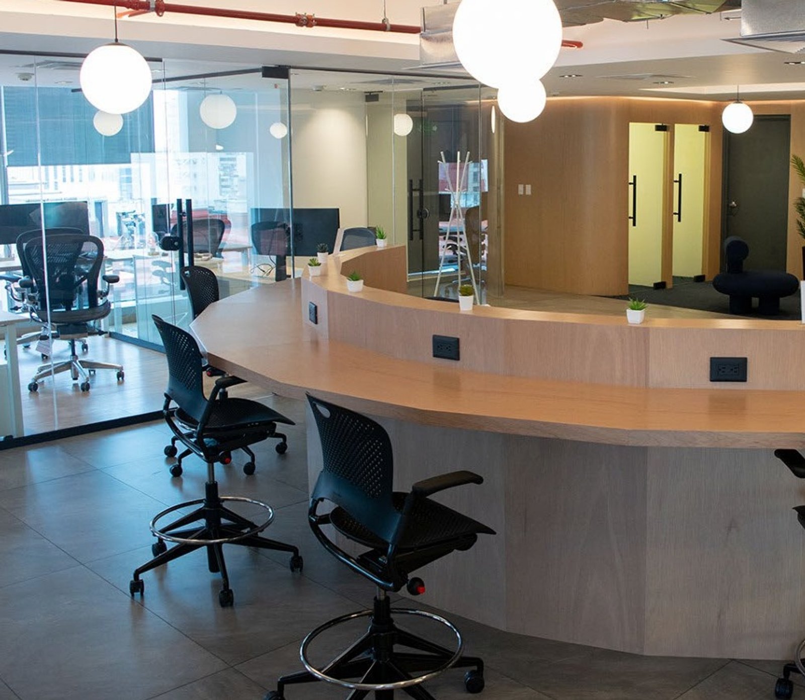 Escritório moderno com ampla bancada curva e cadeiras — projeto oficinas voicess// polanco / atlantico arqs, por atlantico arqs, em Polanco