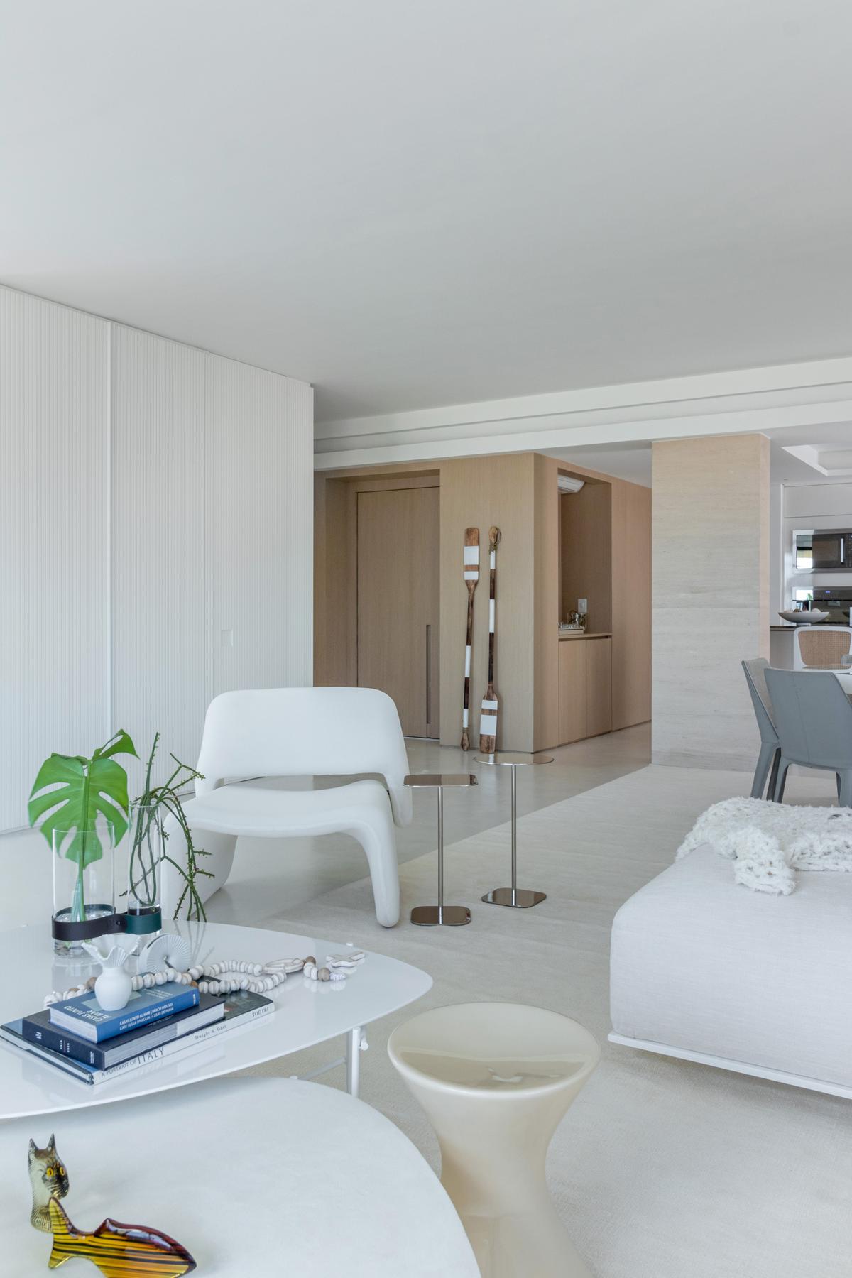 Sala de estar moderna com poltrona branca, mesa de centro orgânica e detalhes em madeira natural — projeto Residencial, por Rodolfo Fontana