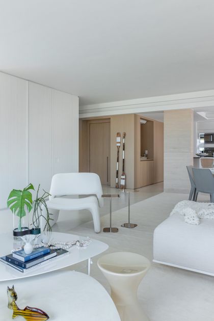 Sala de estar moderna con sillón blanco, mesa ratona orgánica y detalles en madera natural — proyecto Residencial, por  Rodolfo Fontana