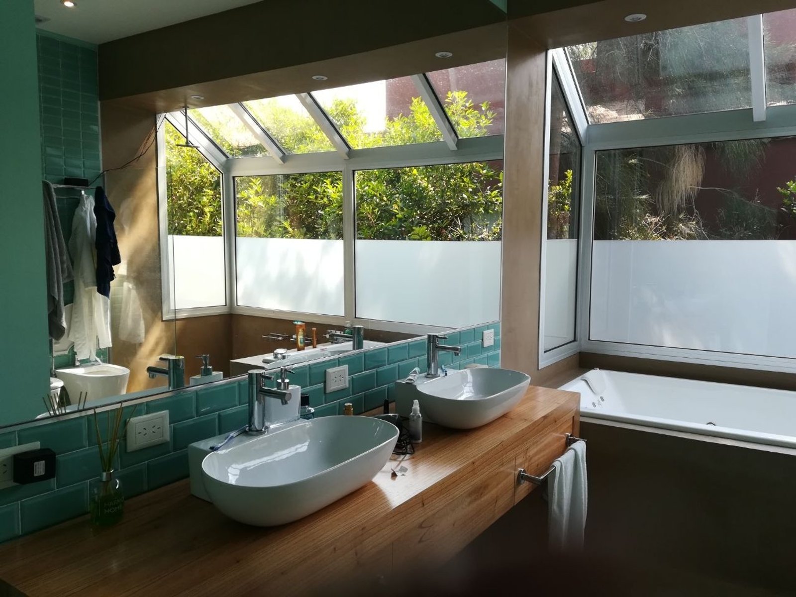 Baño moderno con mucha luz natural, dos lavabos y encimera de madera — proyecto Casa particular en Escobar, por PROTEX, en Belén de Escobar