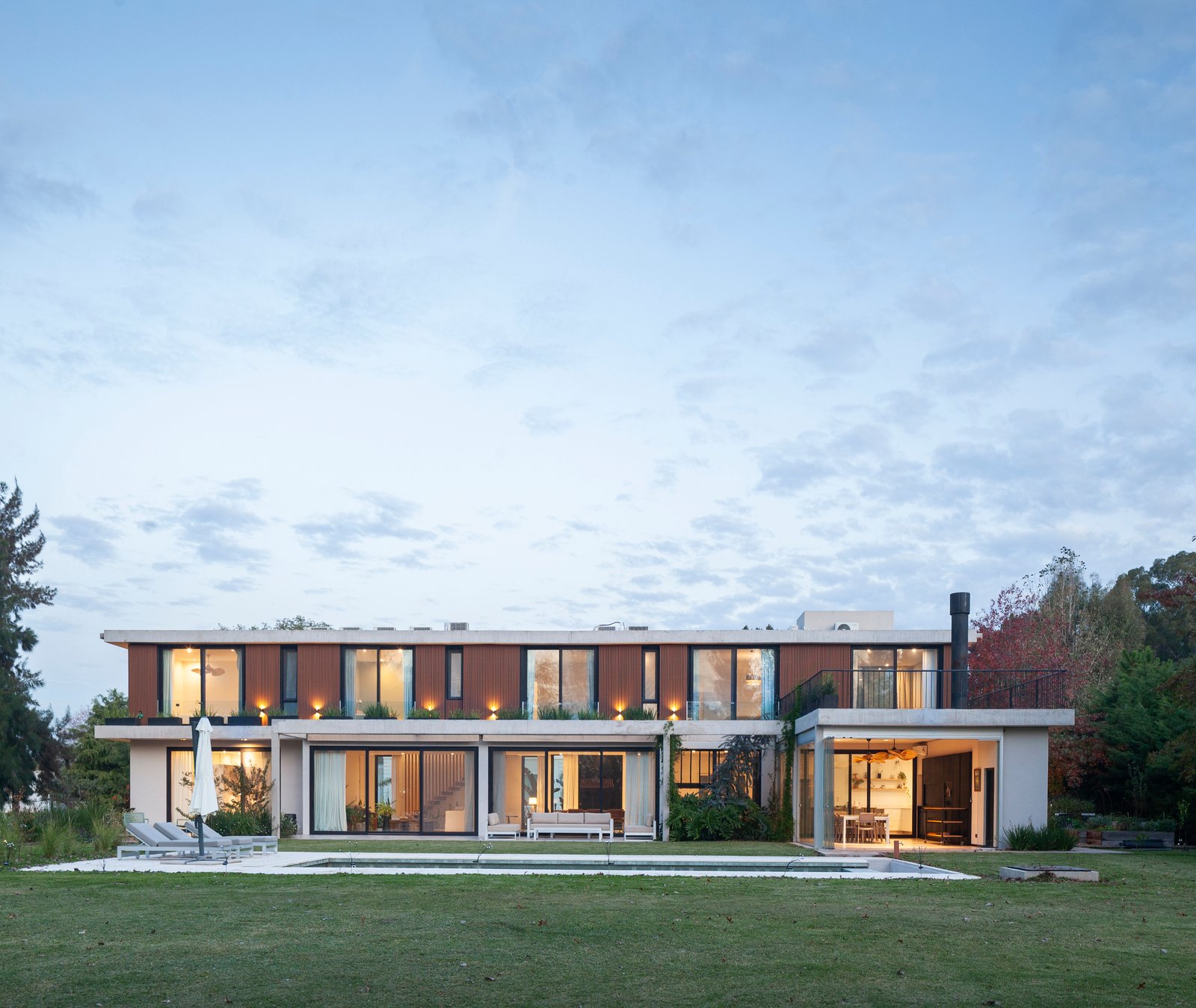 fachada moderna de casa con amplios ventanales y madera — proyecto CASA HS143, por A'PRIMA - Arquitectura Sustentable, en km 7.5 Ruta 25