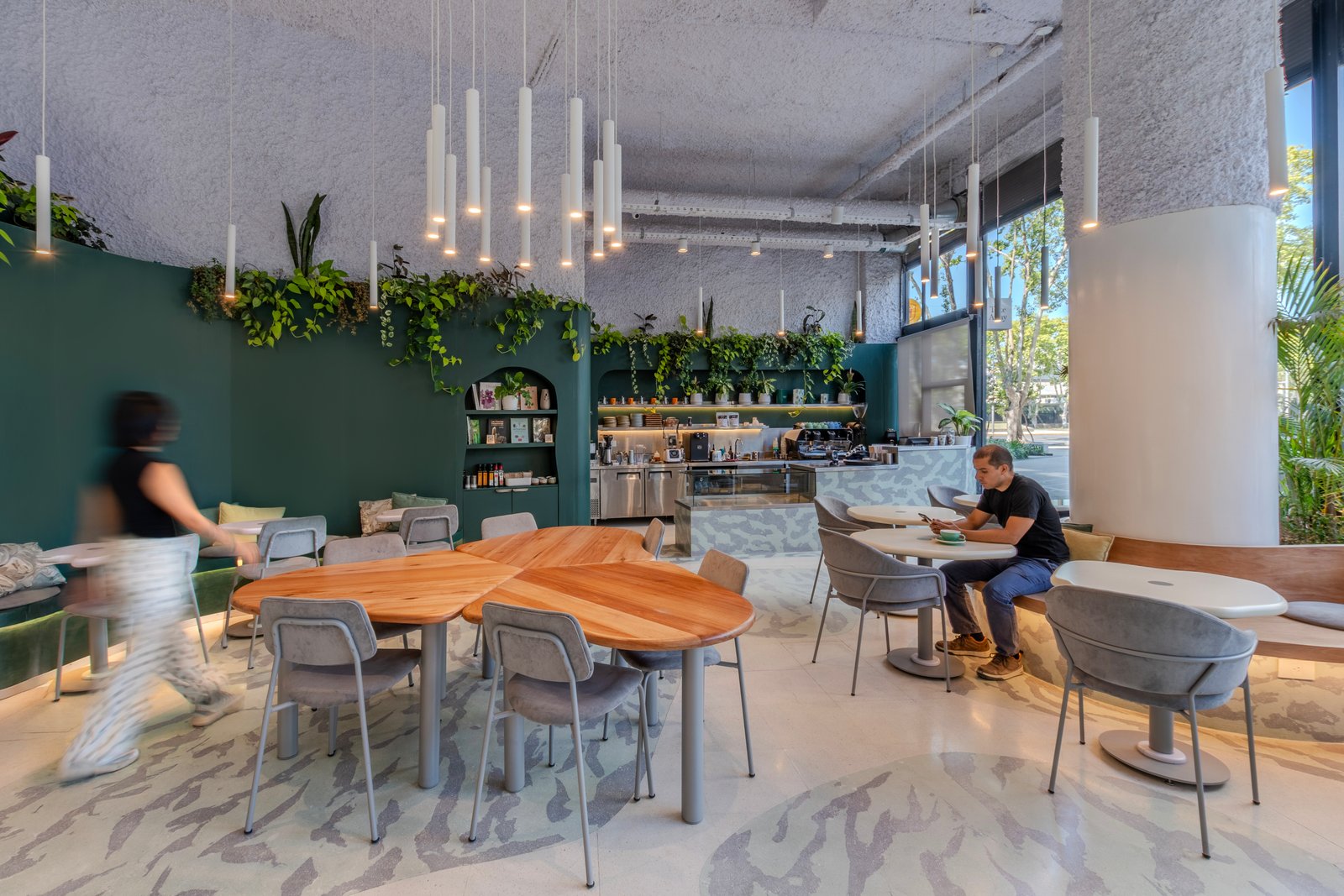 Cafetería moderna con pared verde y mobiliario icónico — proyecto Botanicafe, por KUPERDESIGN CONSTRUCCIONES SRL, en Av. Pres. Ramón Castillo