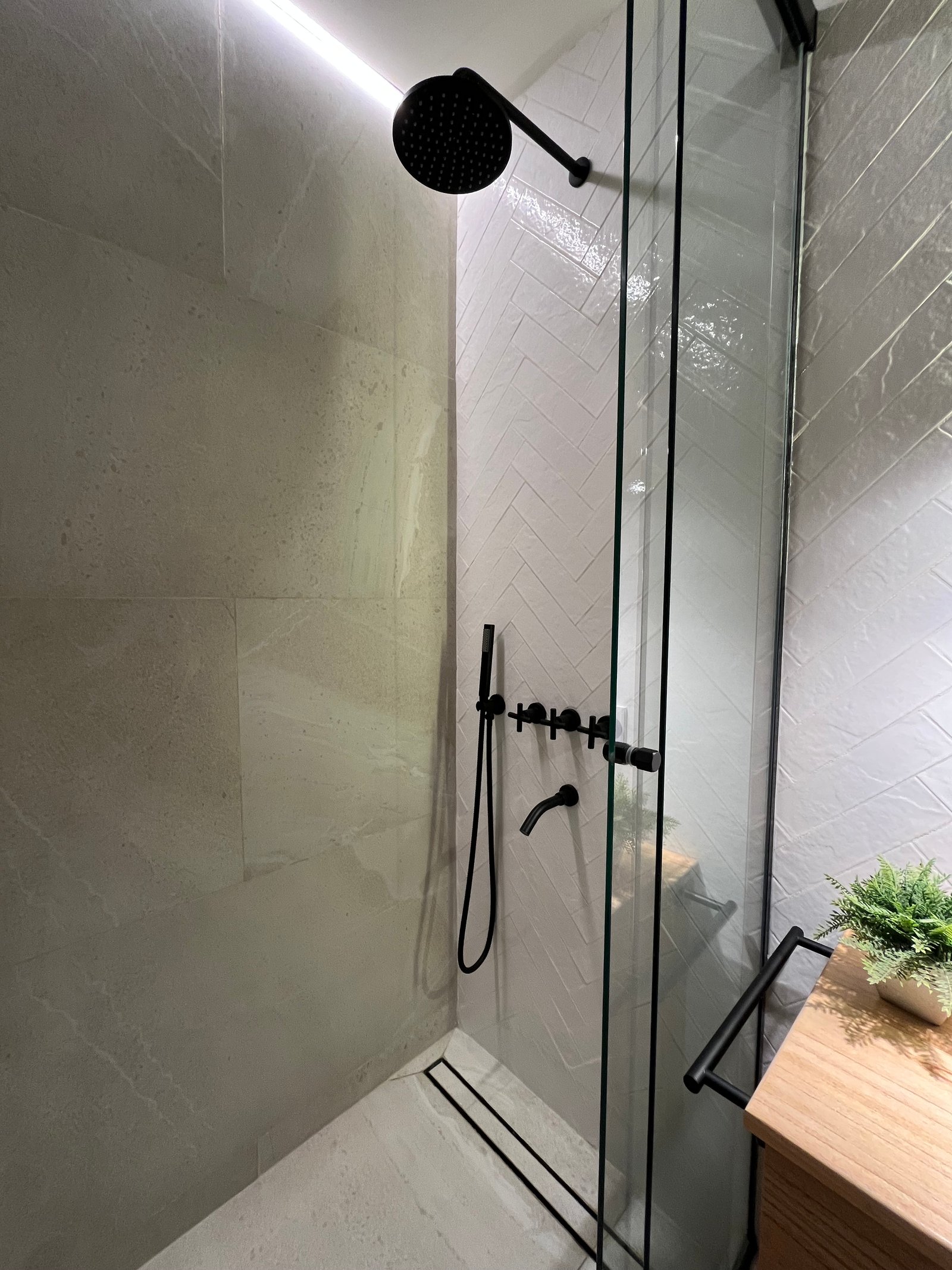 Baño moderno con ducha walk-in y grifería negra — proyecto CASA ANSA, por Barū Arquitectura, en B1674 Sáenz Peña